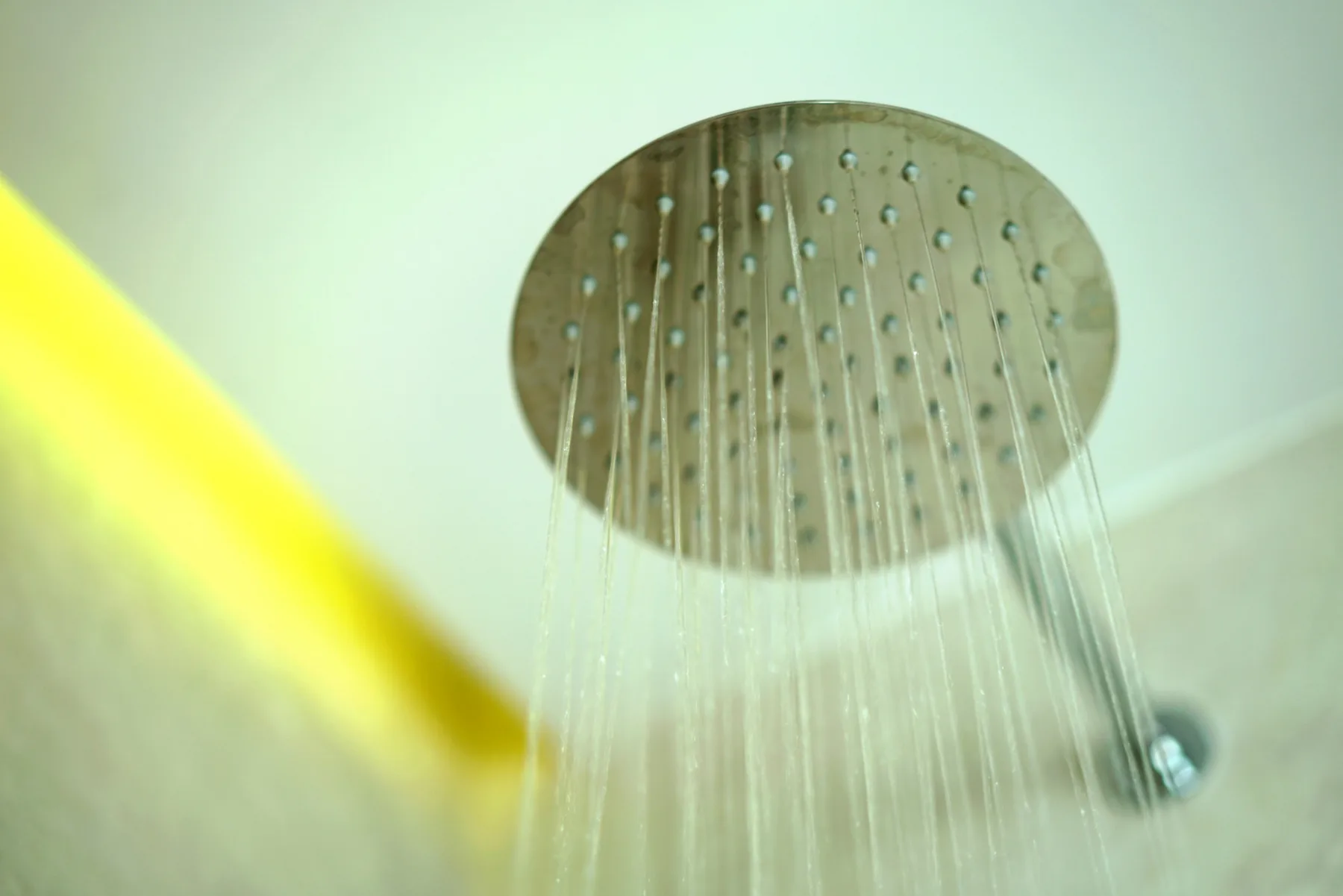 A shower head sprays water from the ceiling.
