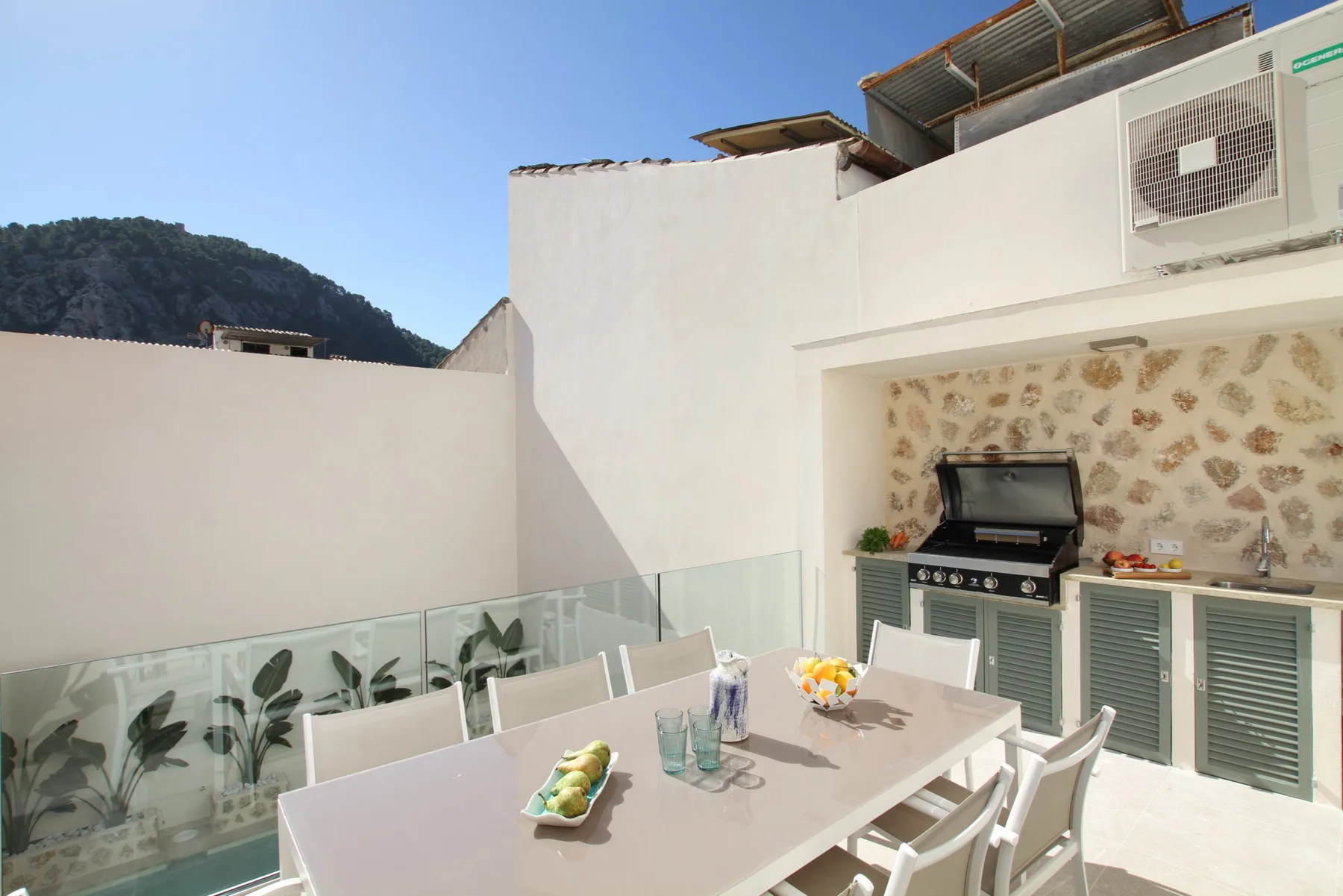 An outdoor dining area with a table and a built-in barbecue.