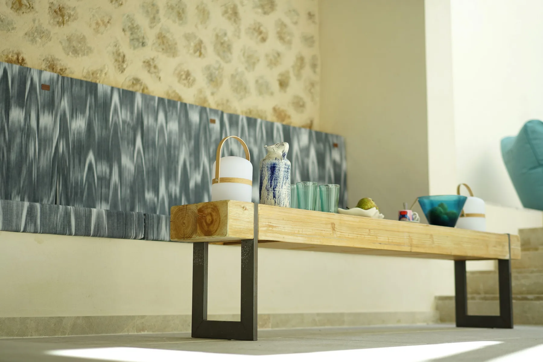 A low display table holds decorative objects against a patterned wall.