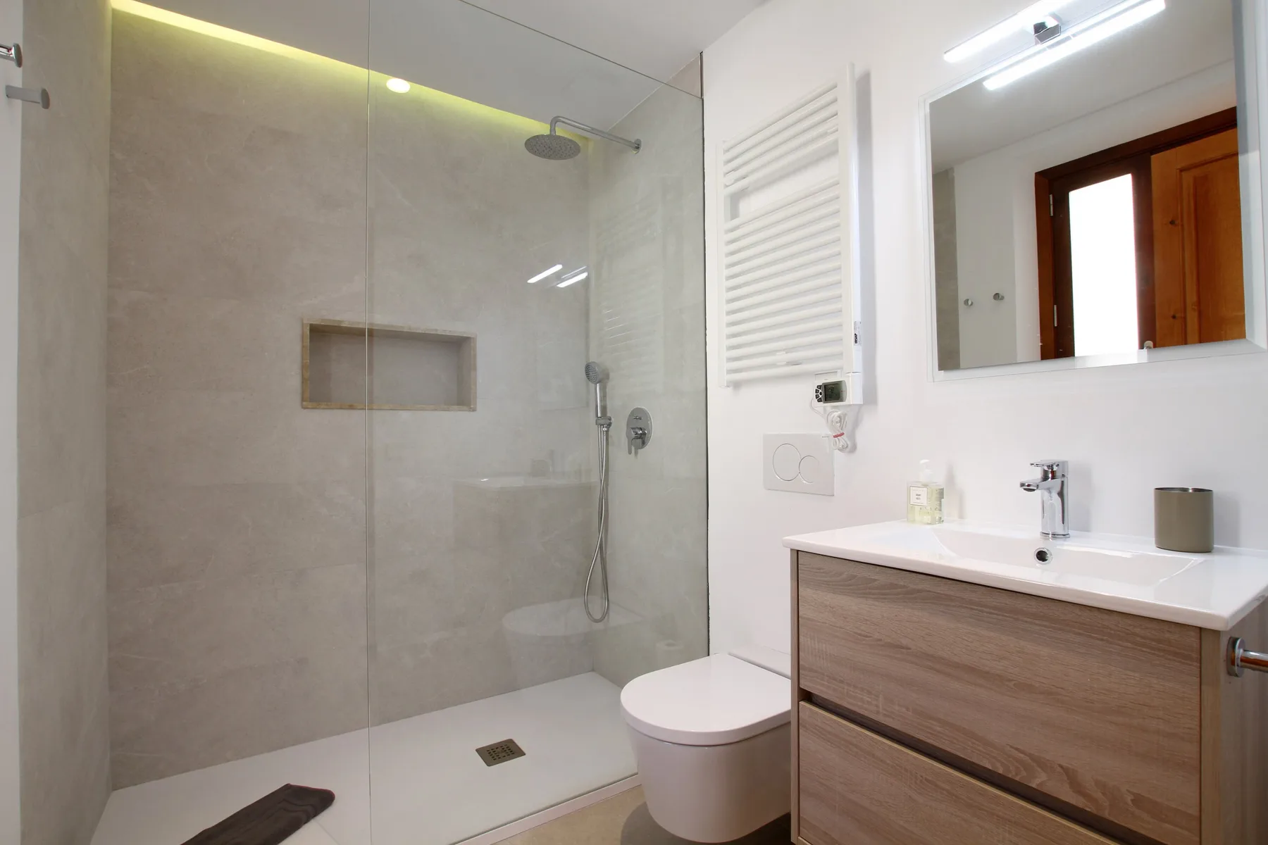 A modern bathroom with a glass shower and a vanity sink.
