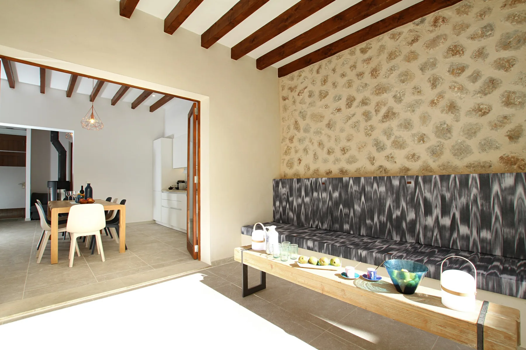 A bright living area with a long bench and a low wooden coffee table.