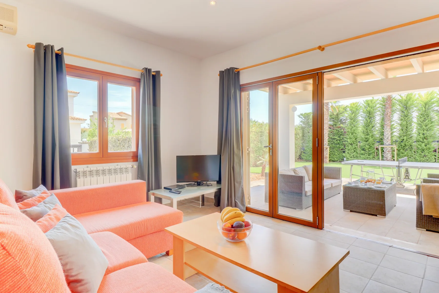 A bright living room opens onto a patio through wide sliding glass doors.