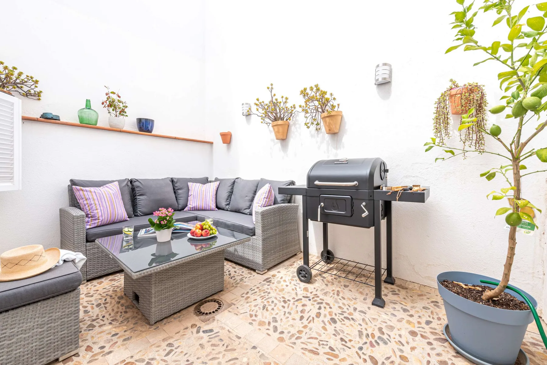 Una zona de estar al aire libre con una mesa y una parrilla.