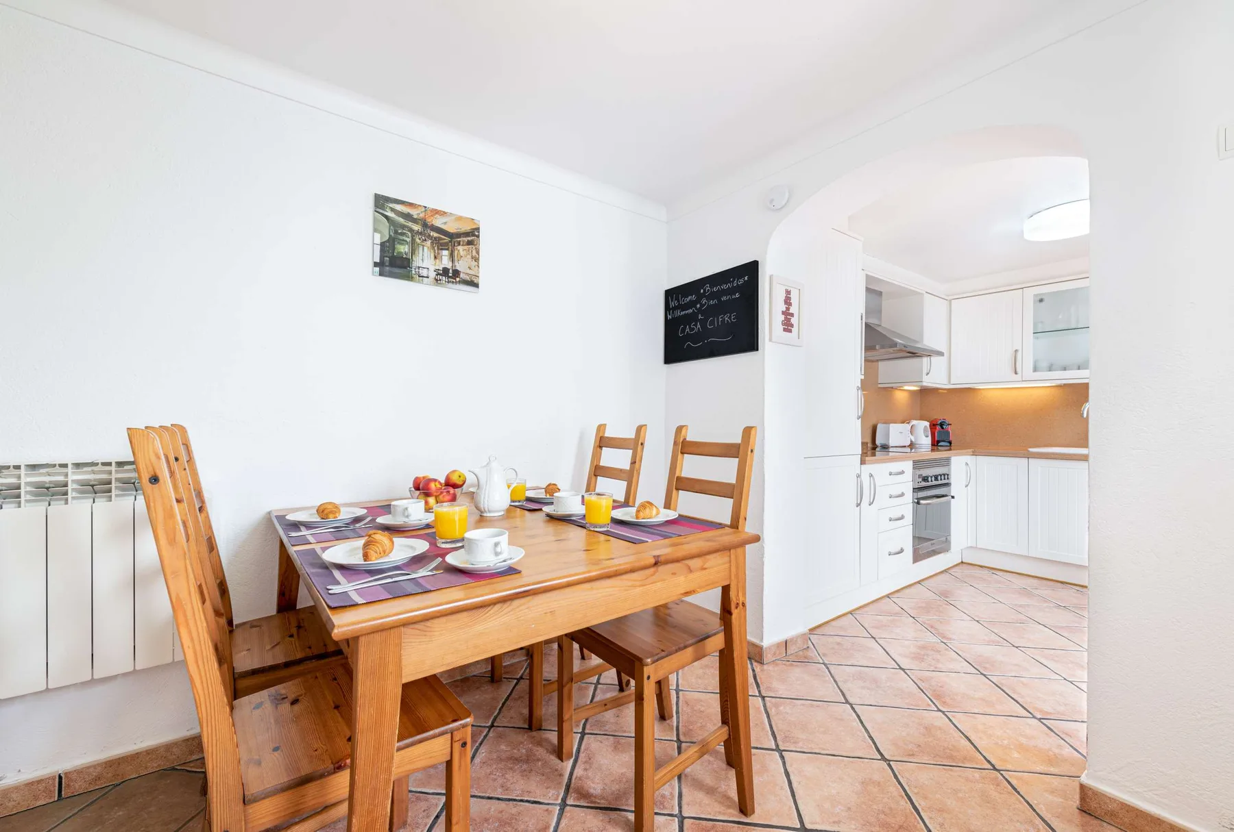 Comedor con una mesa de madera junto a una cocina abierta.