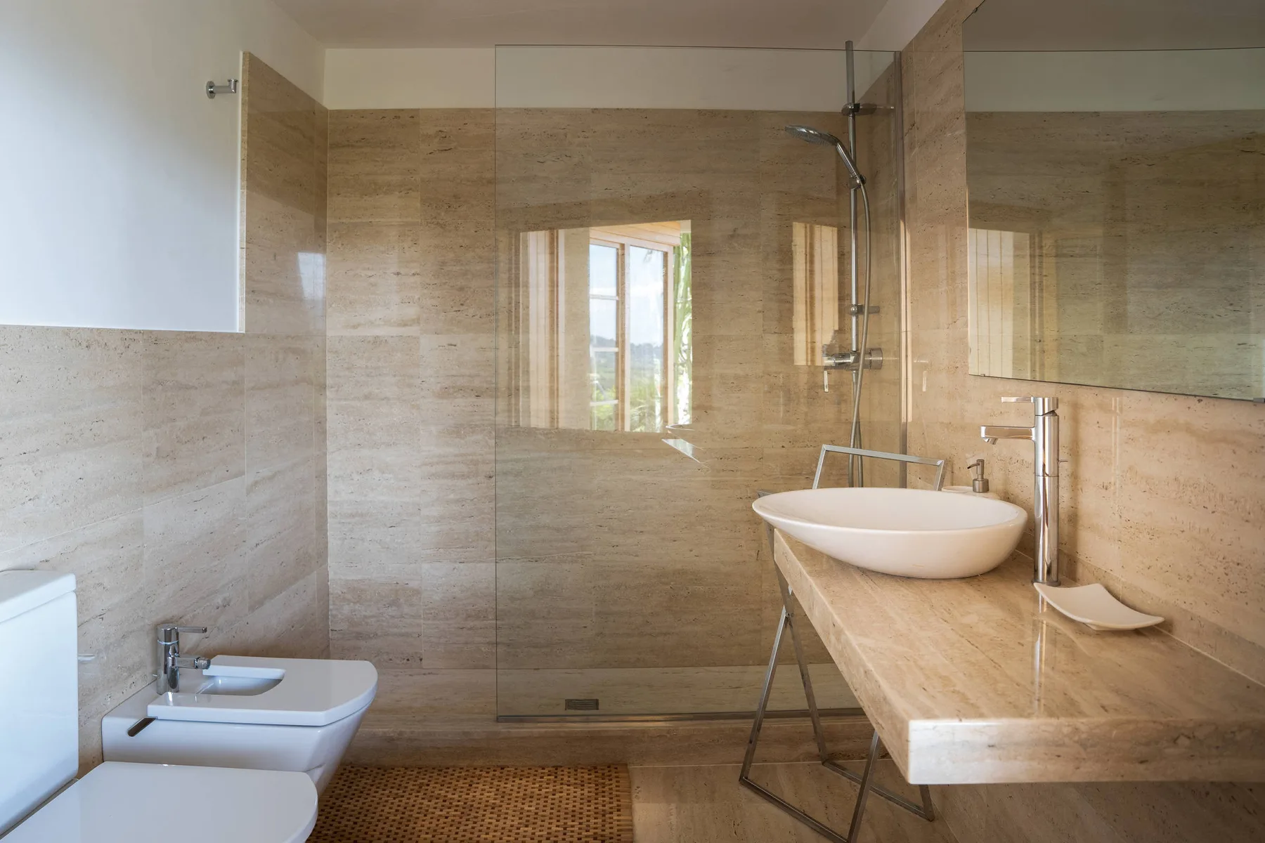 Un baño revestido de azulejos con ducha, bañera y bidé.