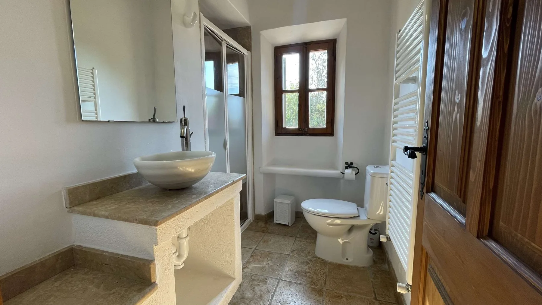Un baño con lavabo, inodoro y una ventana.