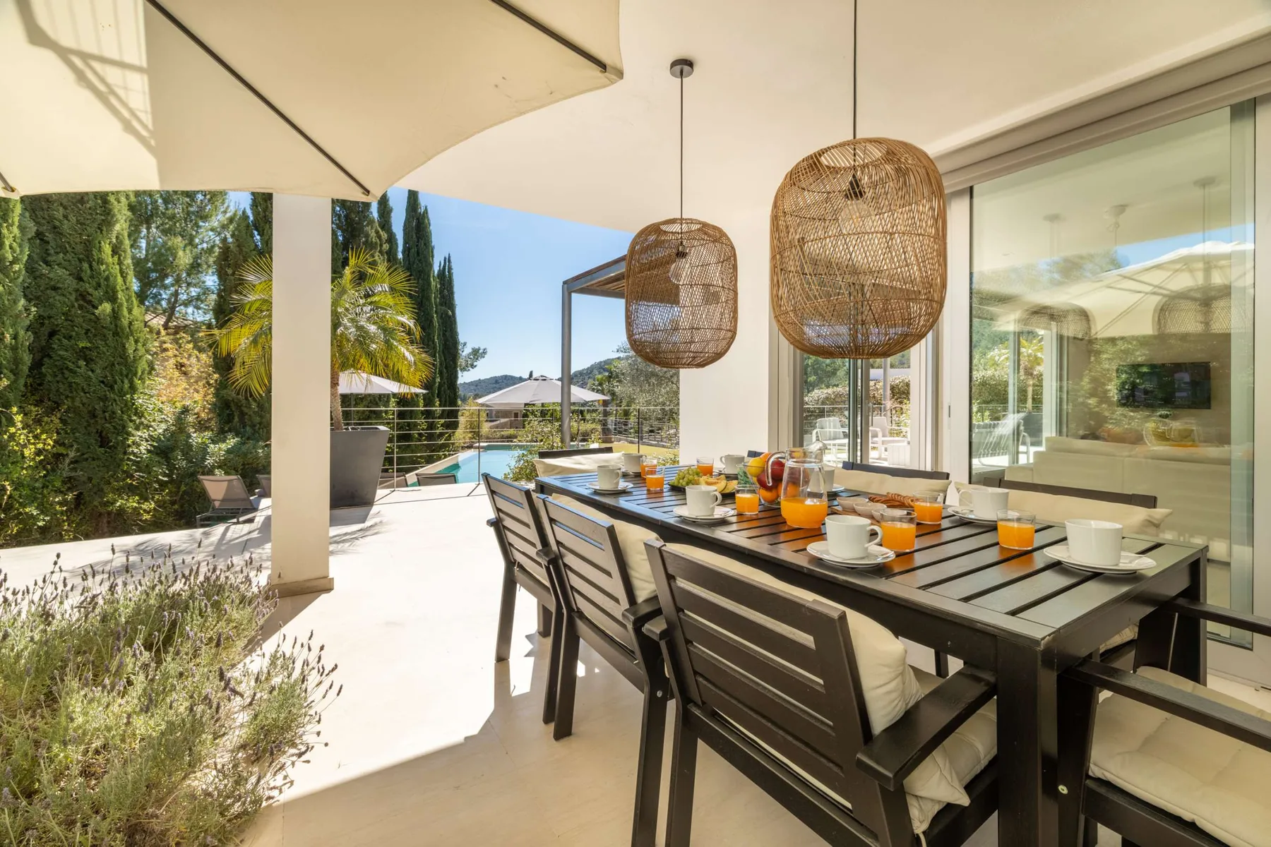 An outdoor dining area with a long table and views of the garden.