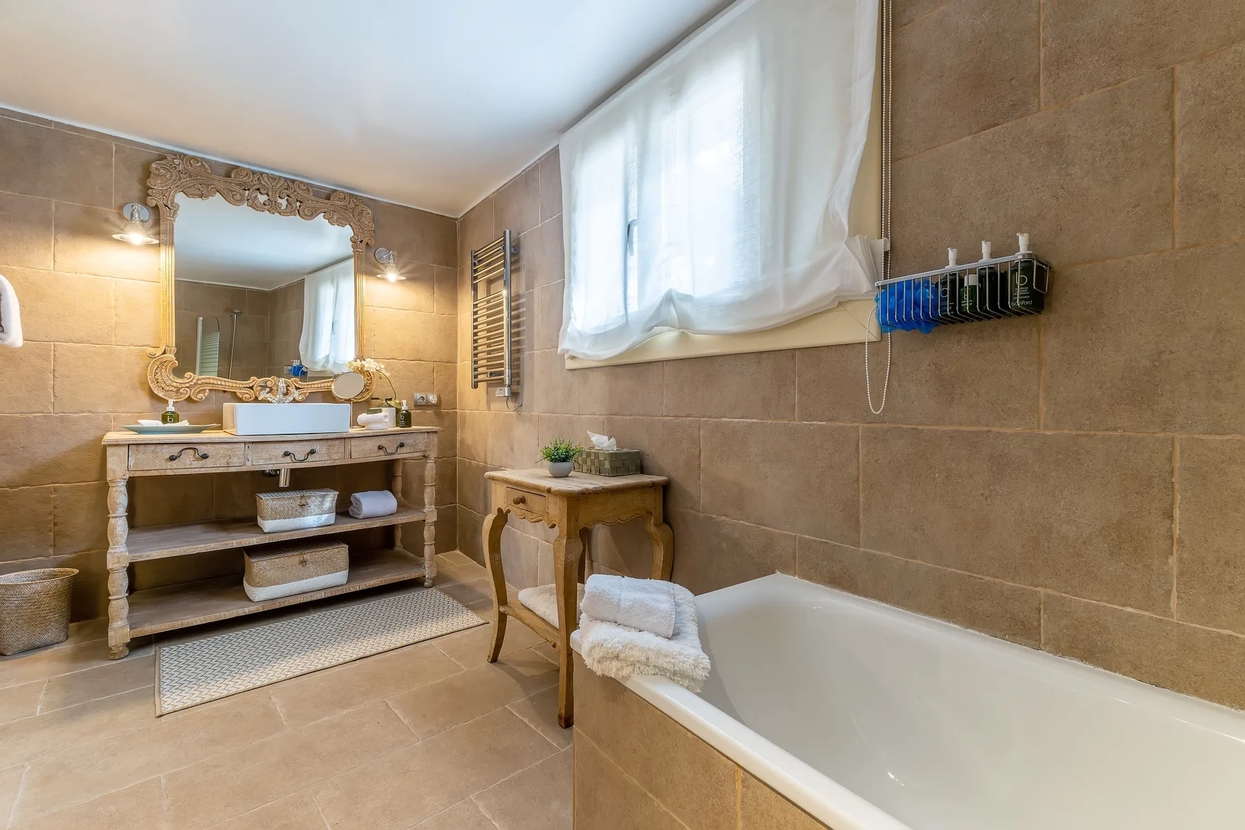 A tiled bathroom with a bathtub, sink, and window.