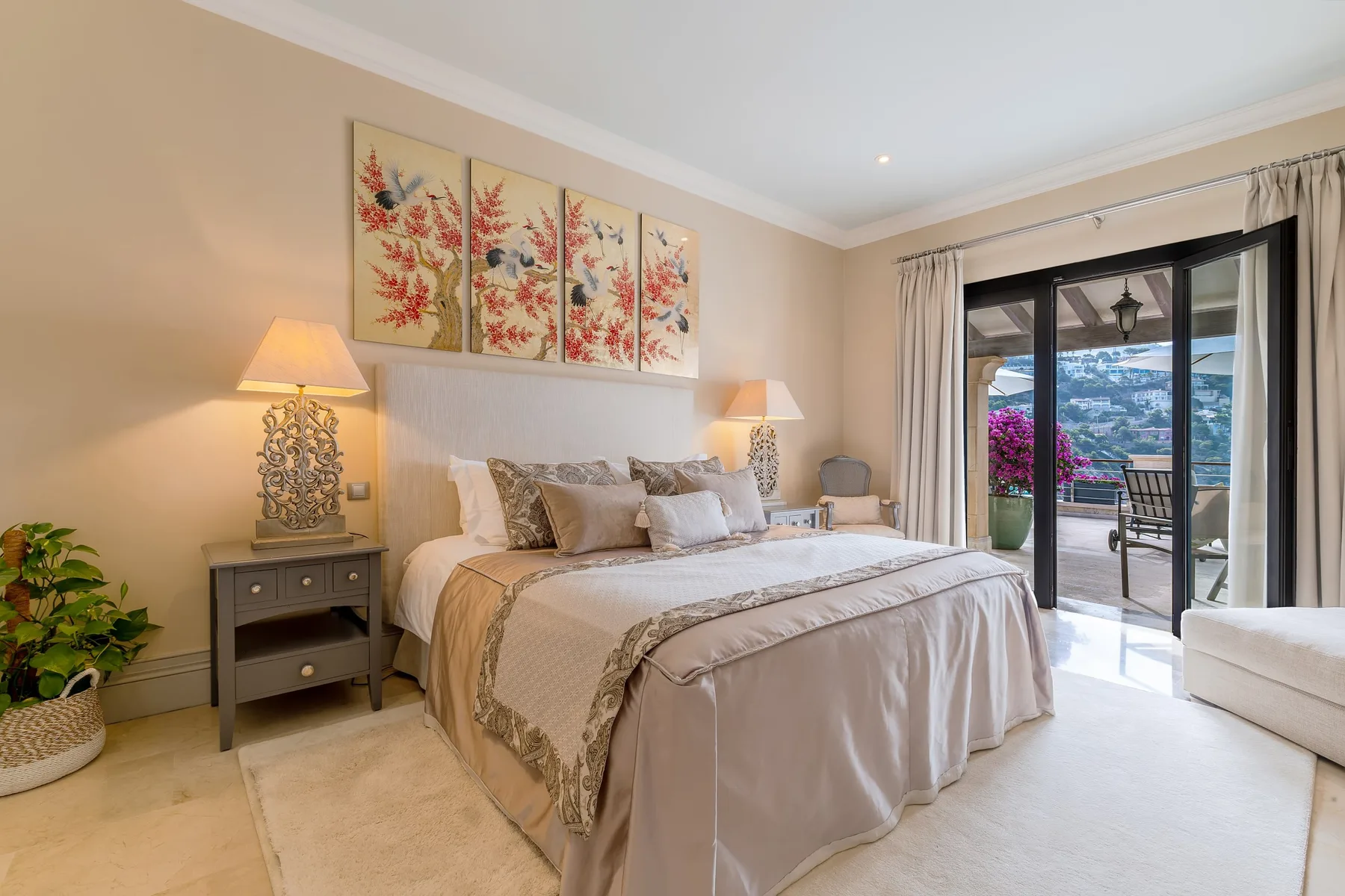 A bedroom with a neatly made bed and sliding glass doors opening onto a balcony.
