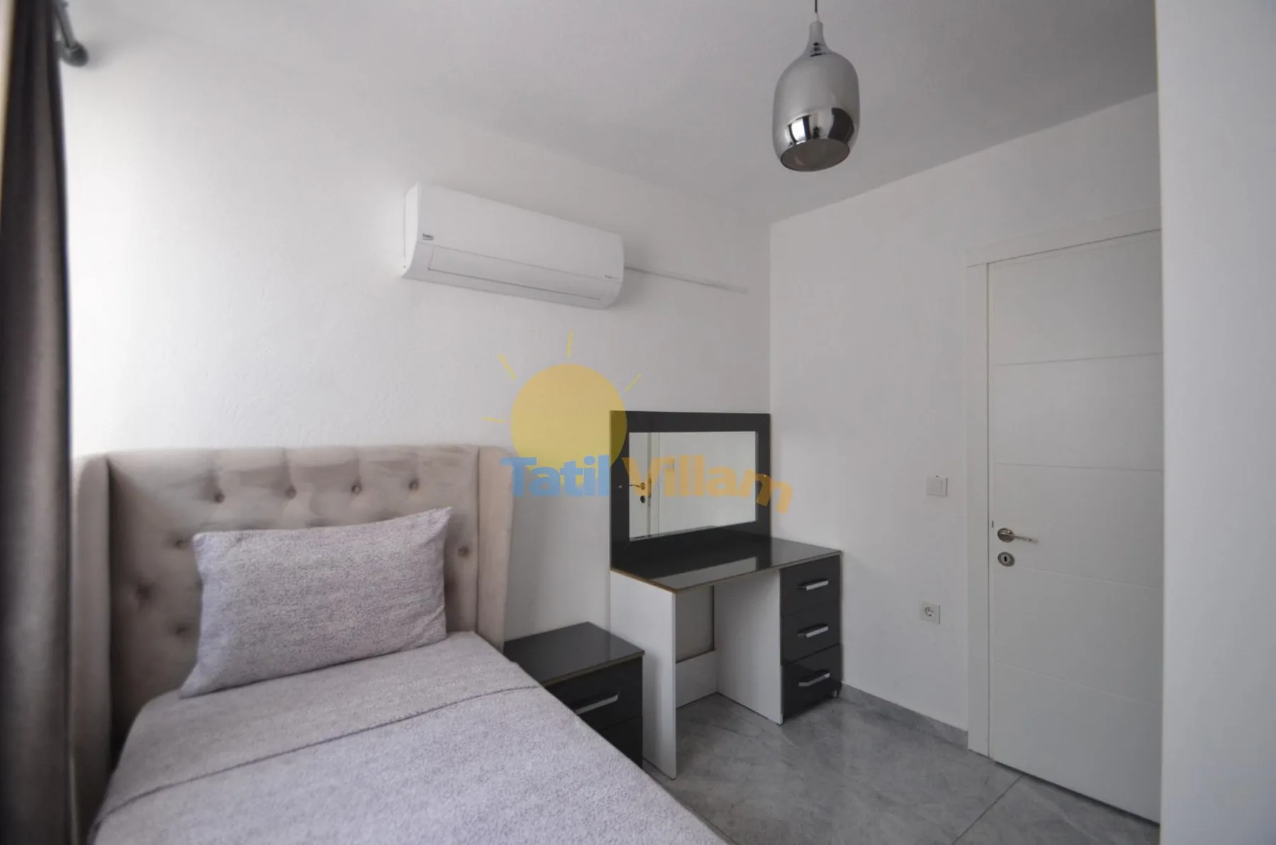 Un dormitorio con una cama, un escritorio y un aire acondicionado en la pared.