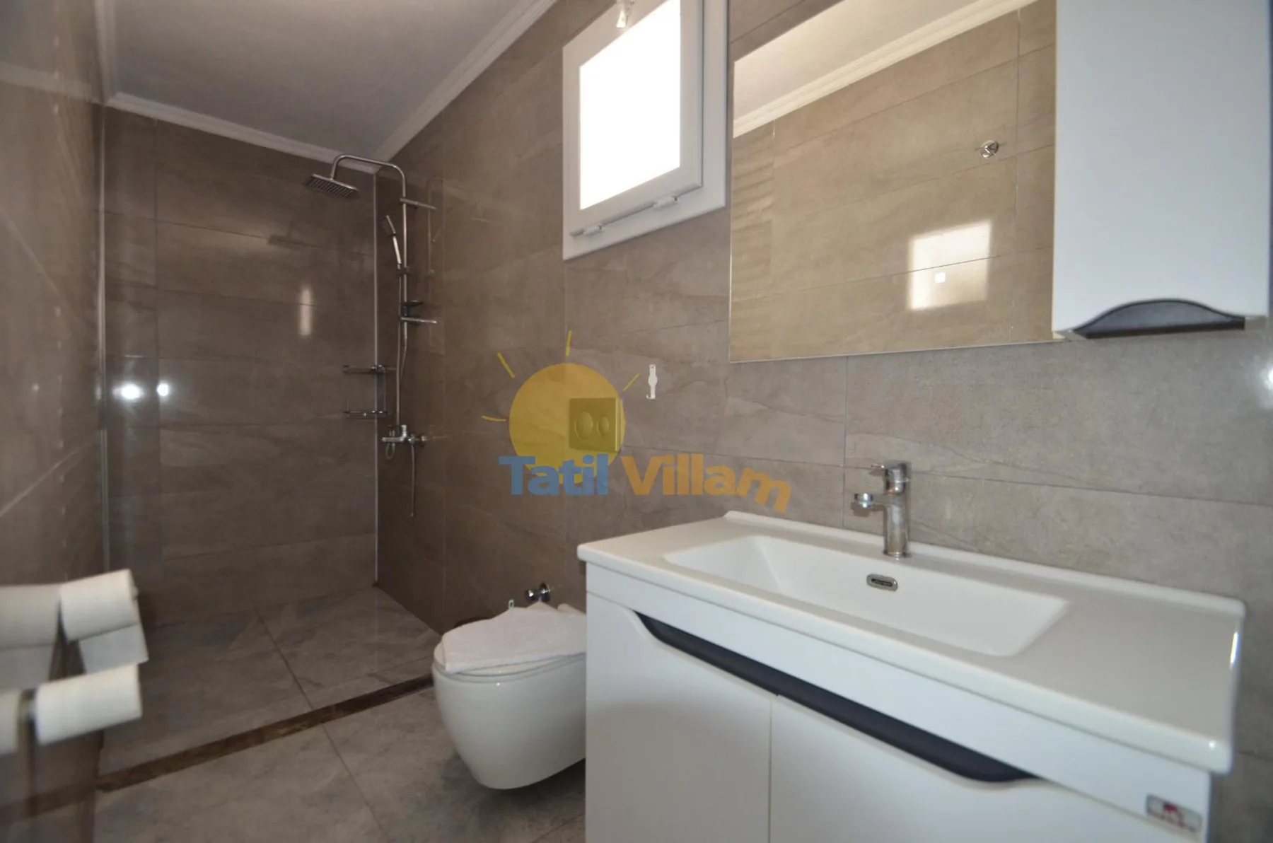Un baño revestido de azulejos con ducha, inodoro y lavabo bajo un espejo.