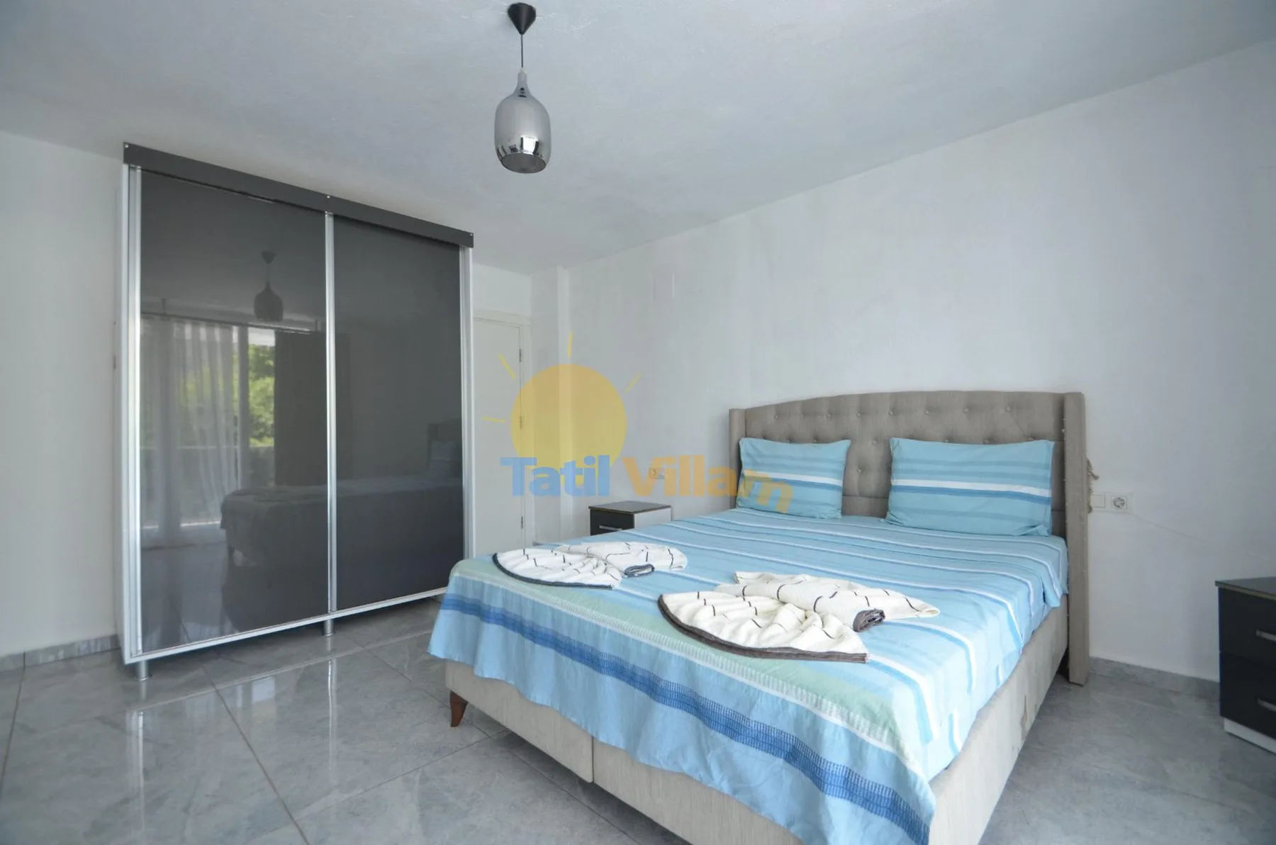Un dormitorio con una cama doble vestida con ropa de cama azul a rayas.