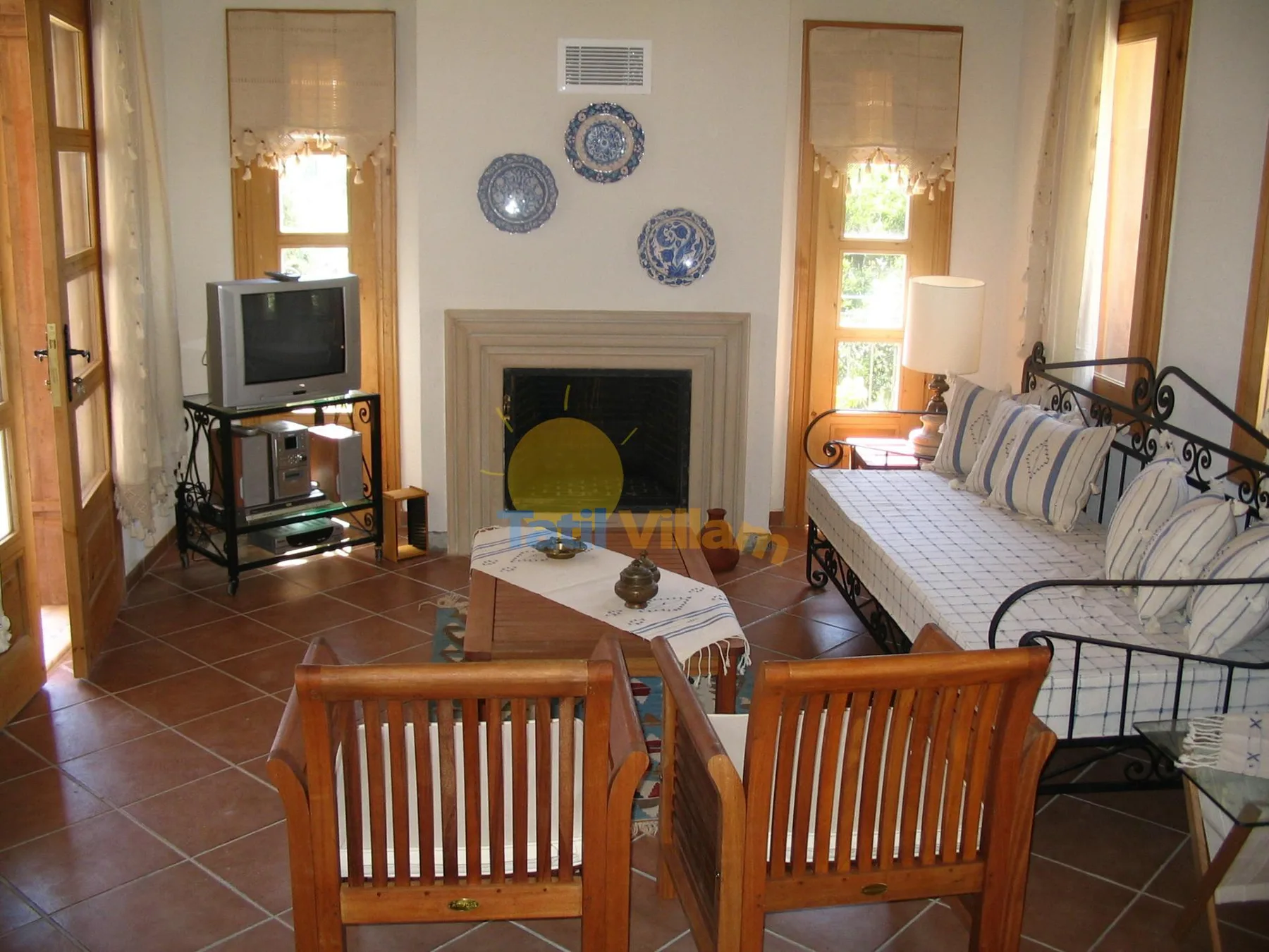 Una sala de estar con chimenea, asientos y un televisor.