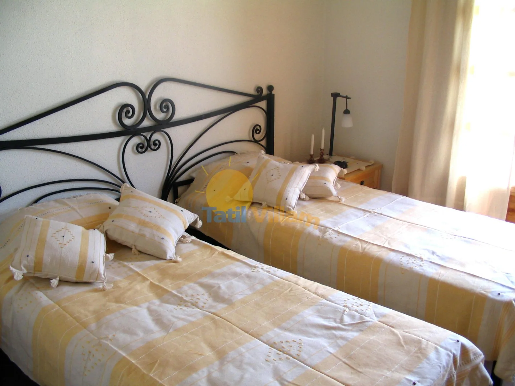 Un dormitorio con dos camas vestidas con ropa de cama amarilla y blanca.