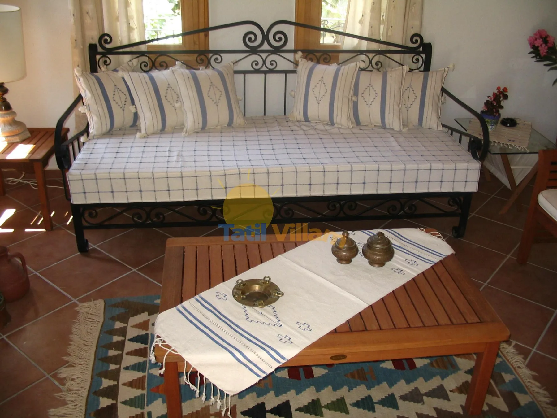 Una zona de estar con un diván y una mesa de centro de madera delante.