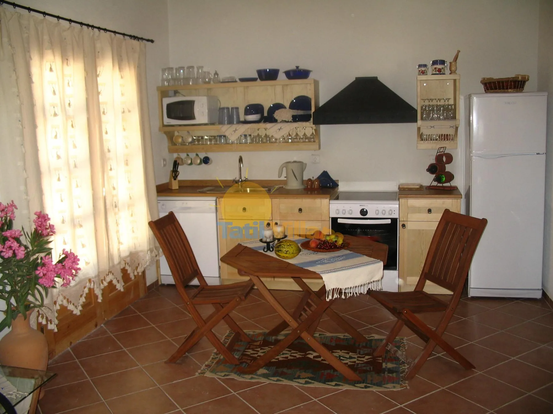 Una cocina y comedor con una mesa de madera y sillas.