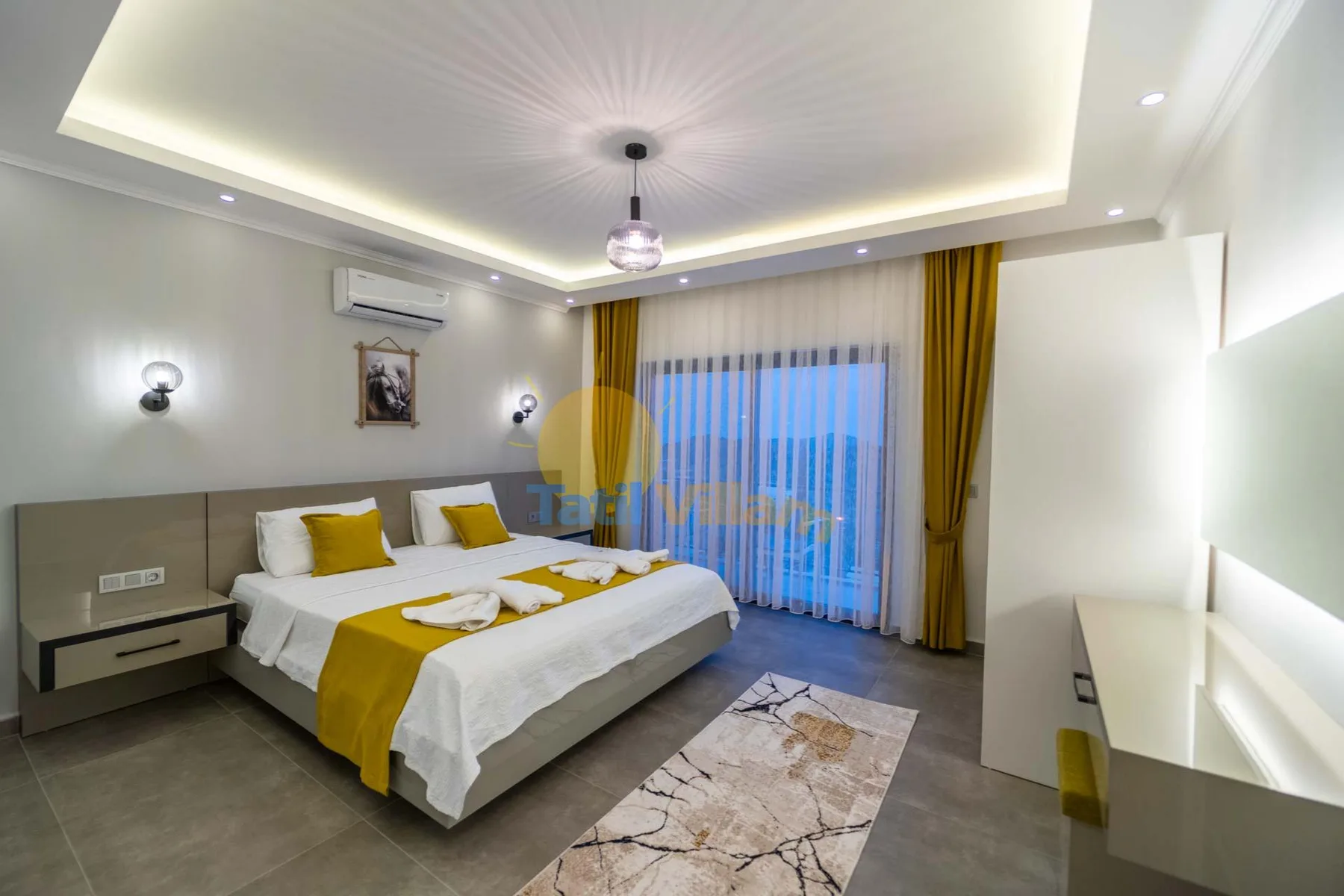A bedroom with a neatly made bed and mustard-yellow accents.