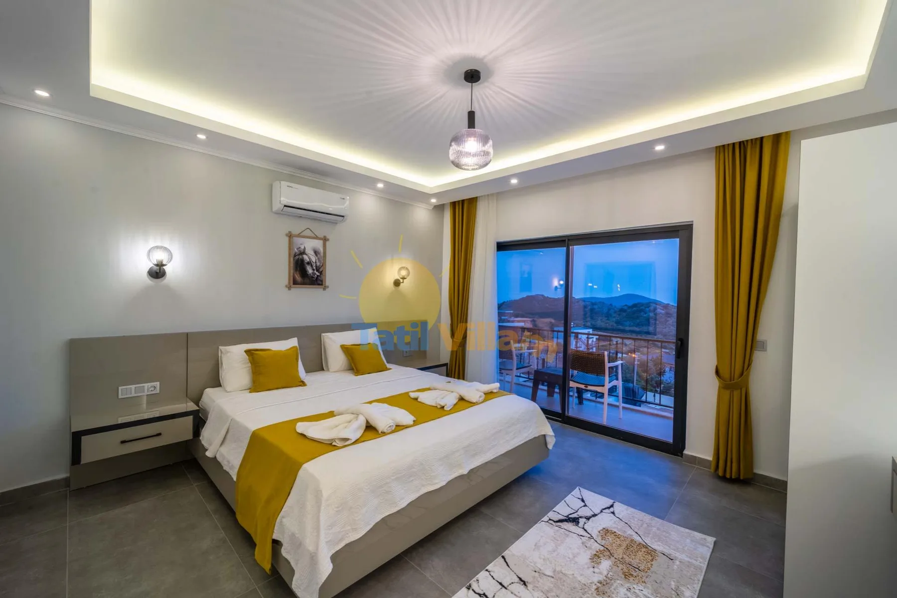 A bedroom with a double bed and glass doors opening onto a balcony.