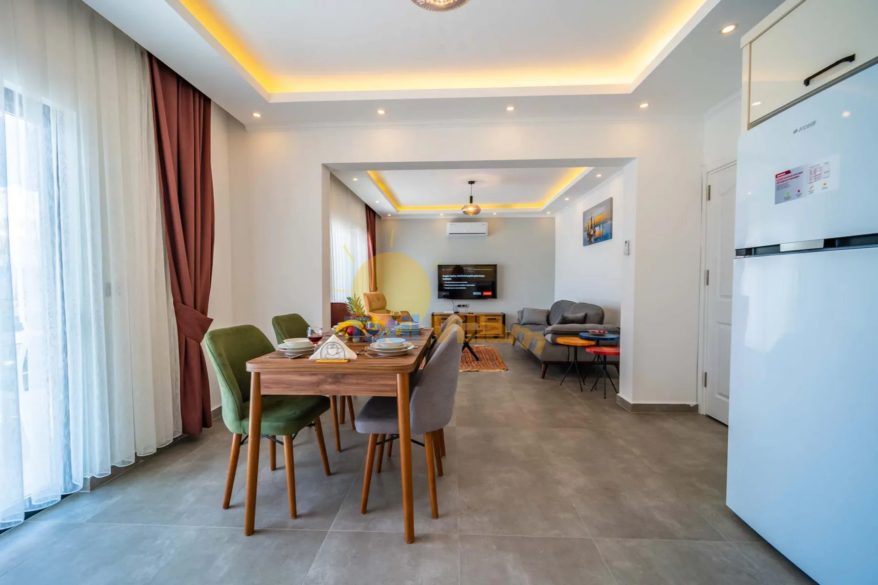 A dining and living area with a table, seating, and a television.