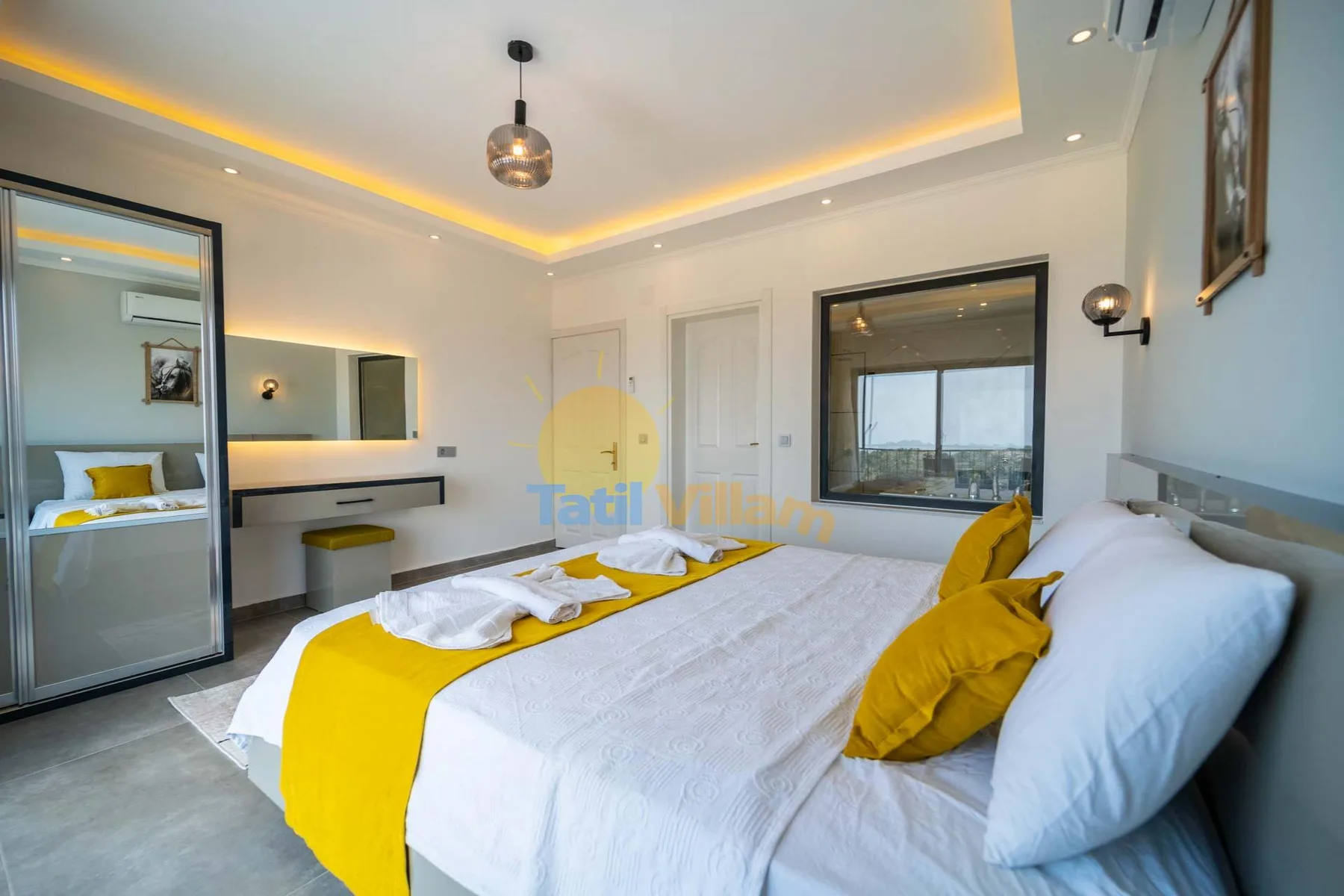 A bedroom with a bed dressed in white linens and a bright yellow runner.