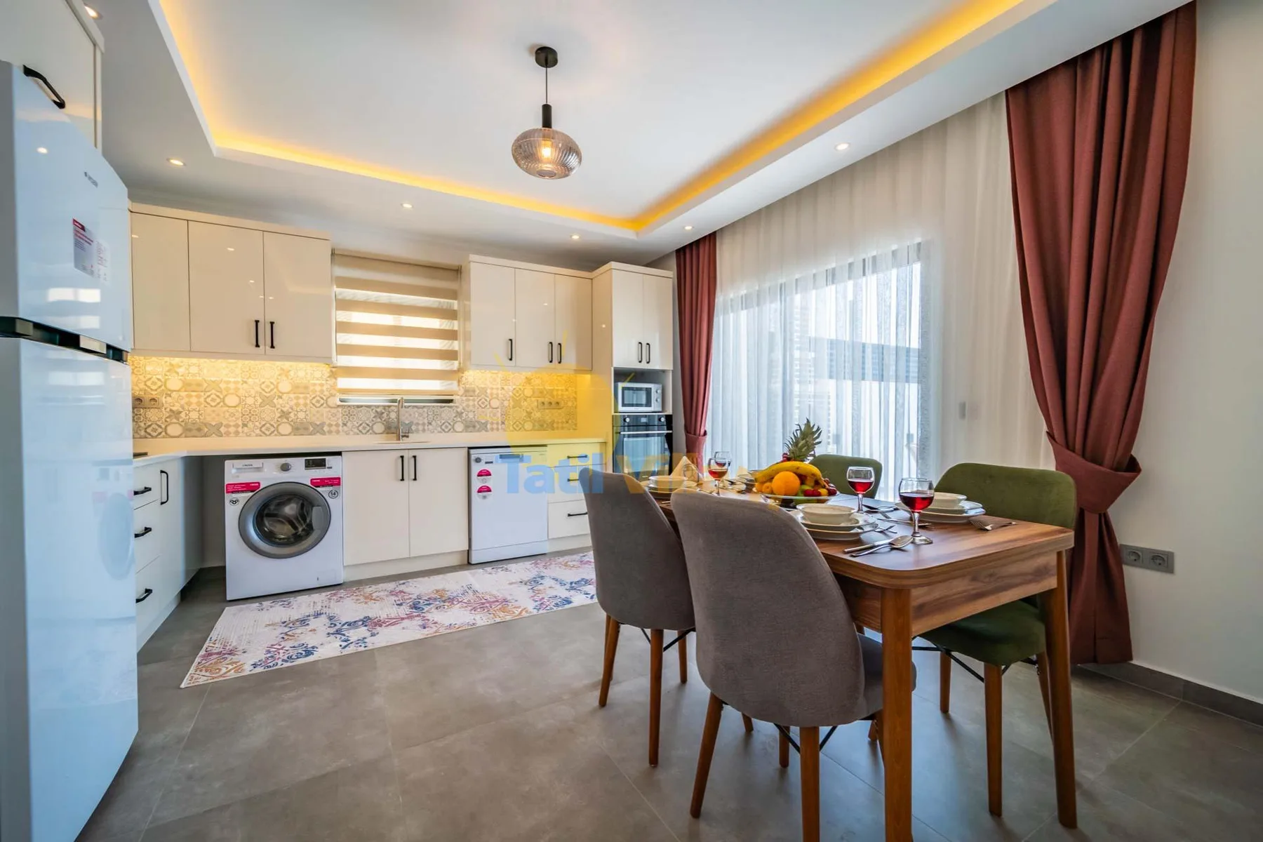 A dining area beside a compact kitchen, with a set table by the window.