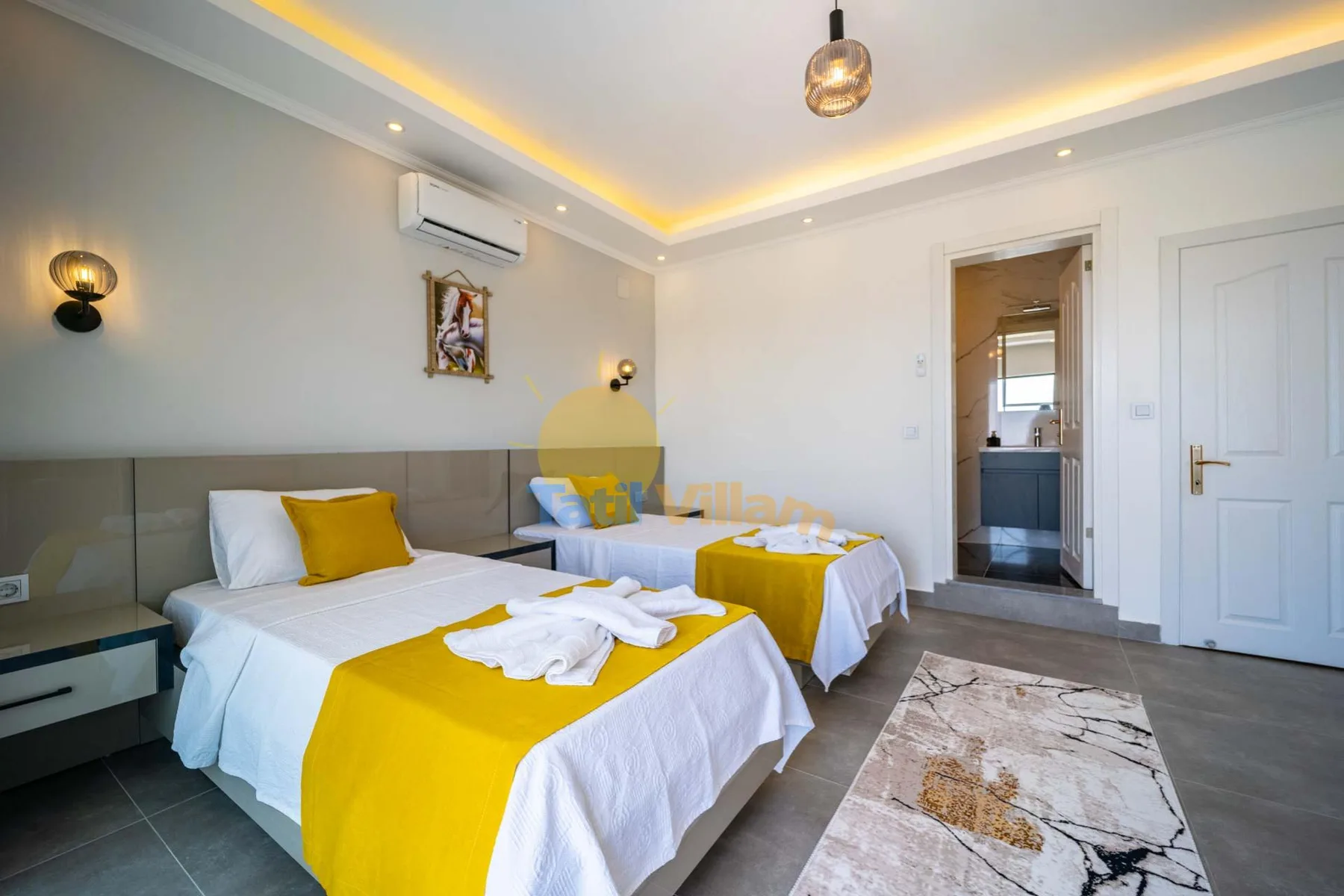 A bedroom with two beds dressed in white and yellow linens.