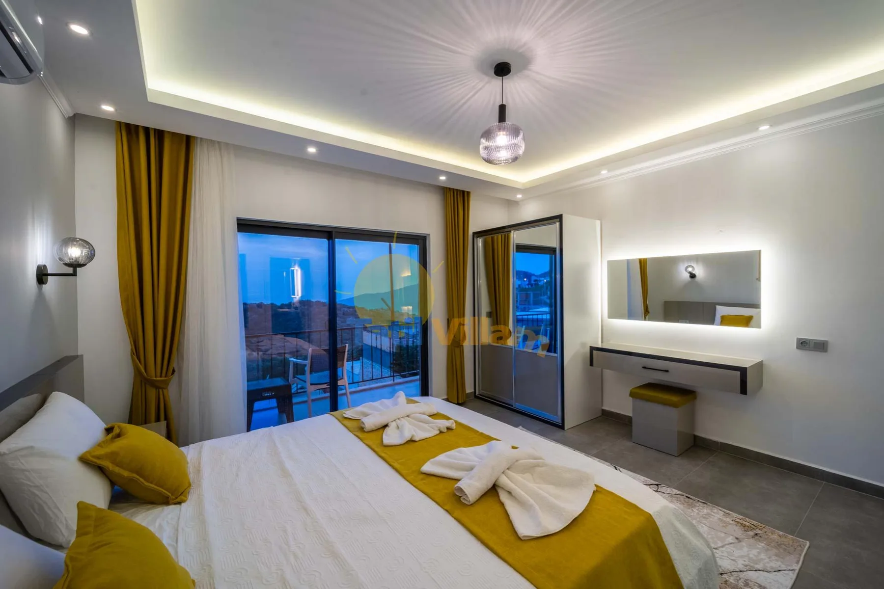 A bedroom with a bed, yellow curtains, and sliding glass doors.