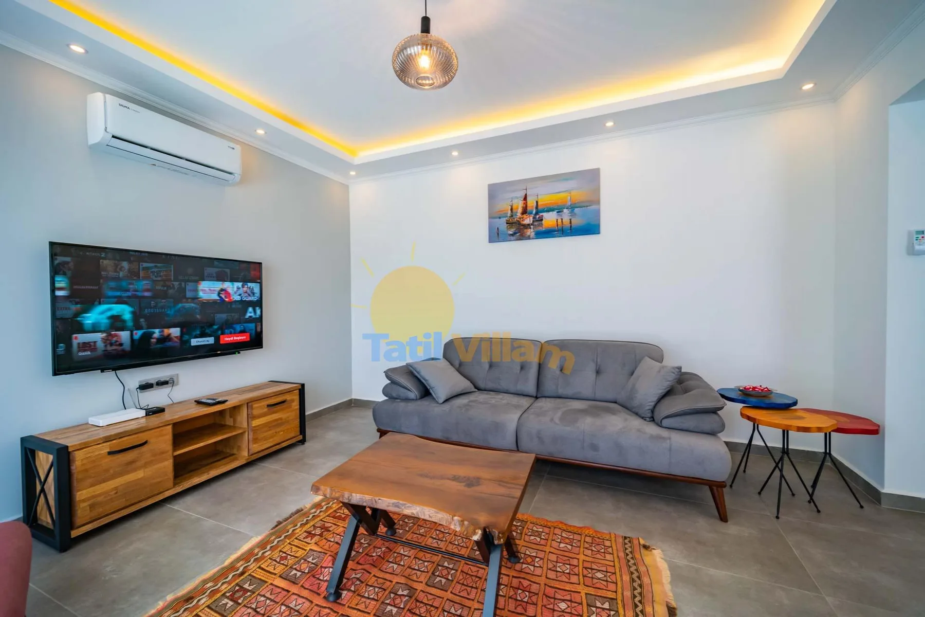 A living room with a gray sofa, television, and wooden coffee table.