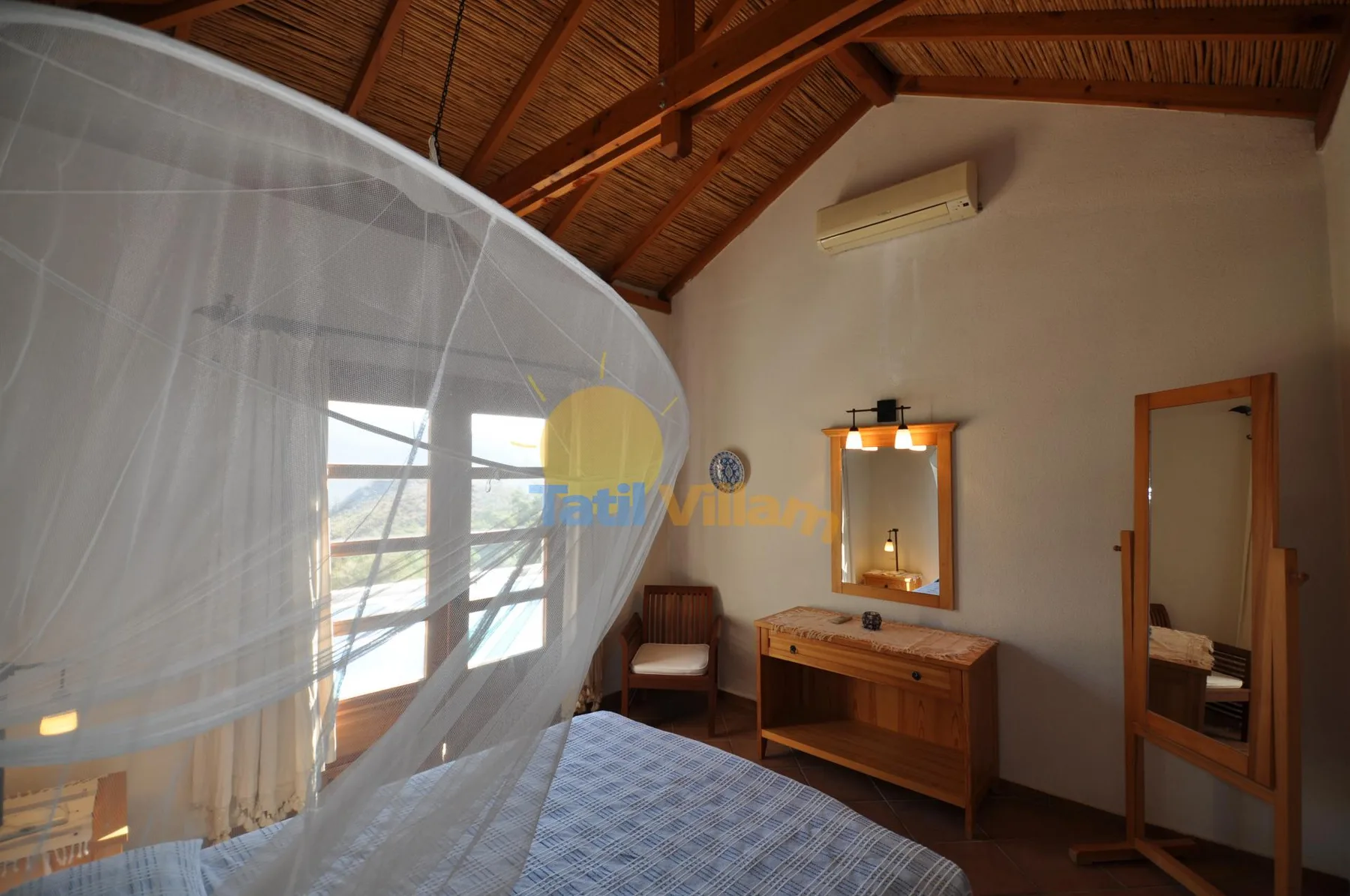 A bedroom with a bed beneath a wooden vaulted ceiling and a dresser with a mirror.