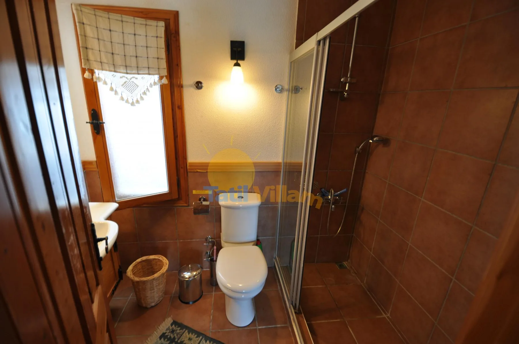 A bathroom with a toilet, sink, and glass-enclosed shower.