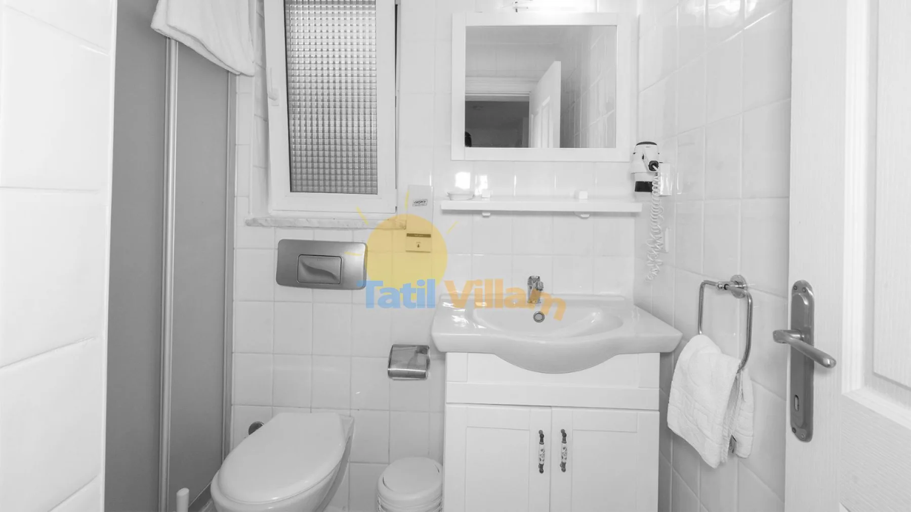 Un baño con azulejos, lavabo, espejo e inodoro.