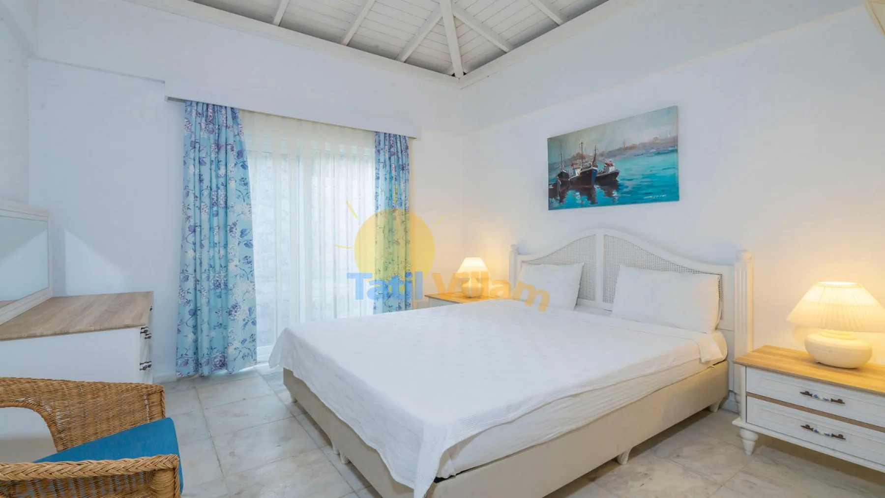 Un dormitorio luminoso con una cama grande y cortinas azules.