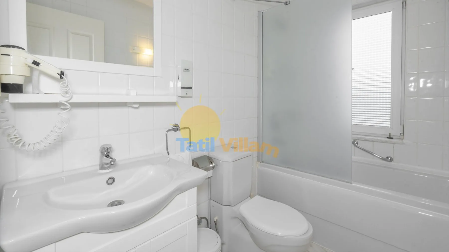 Un baño luminoso con lavabo, inodoro y bañera.