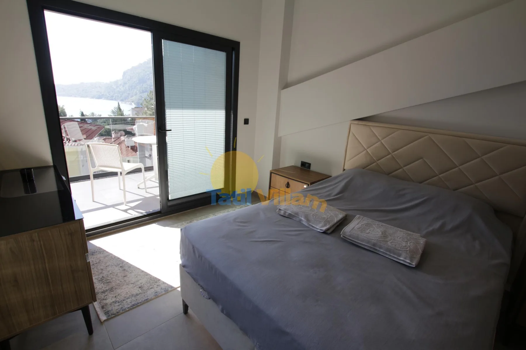 Un dormitorio con una cama junto a una puerta corrediza de vidrio que da a un balcón.