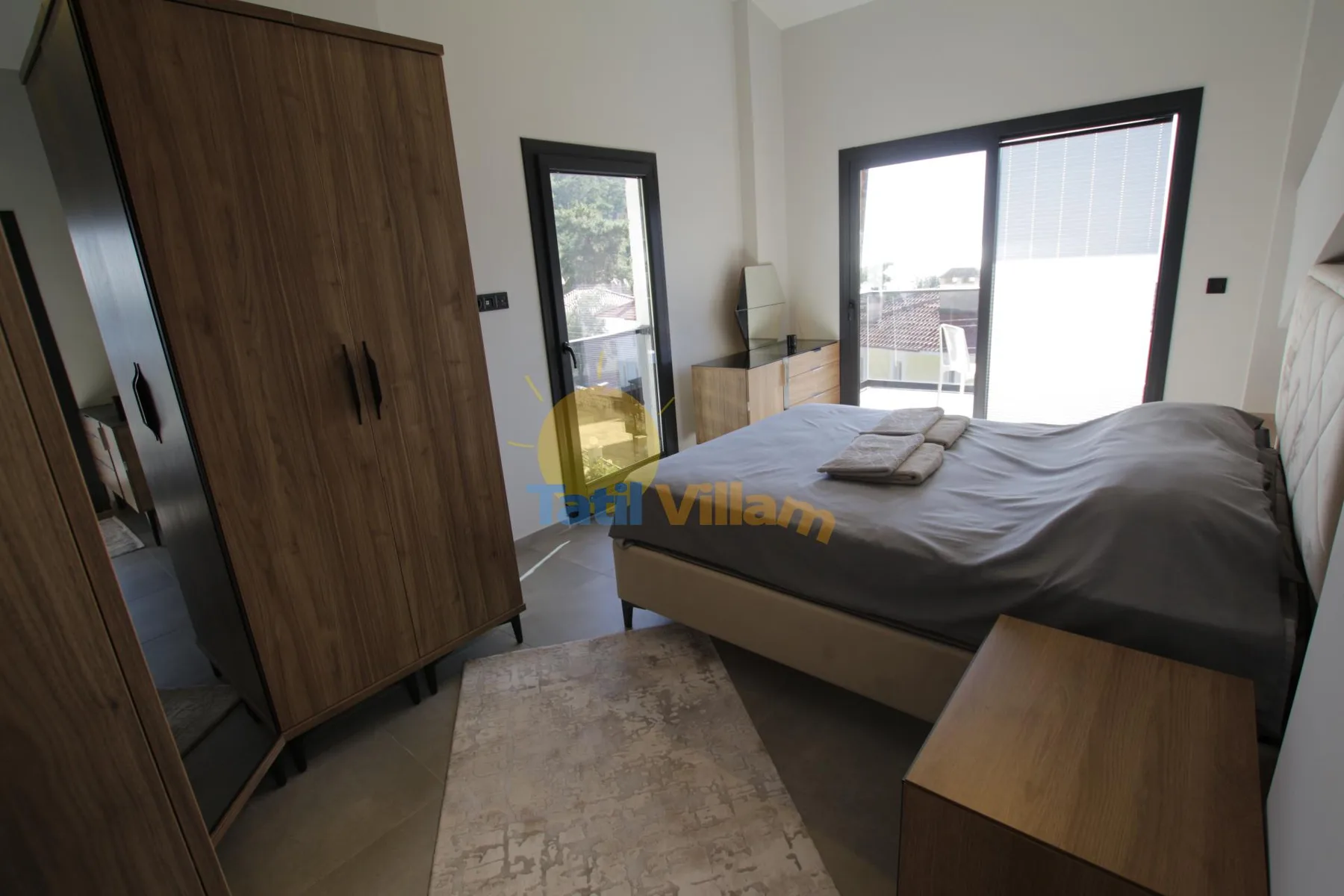 Un dormitorio con una cama, armarios de madera y una gran puerta corrediza de vidrio.