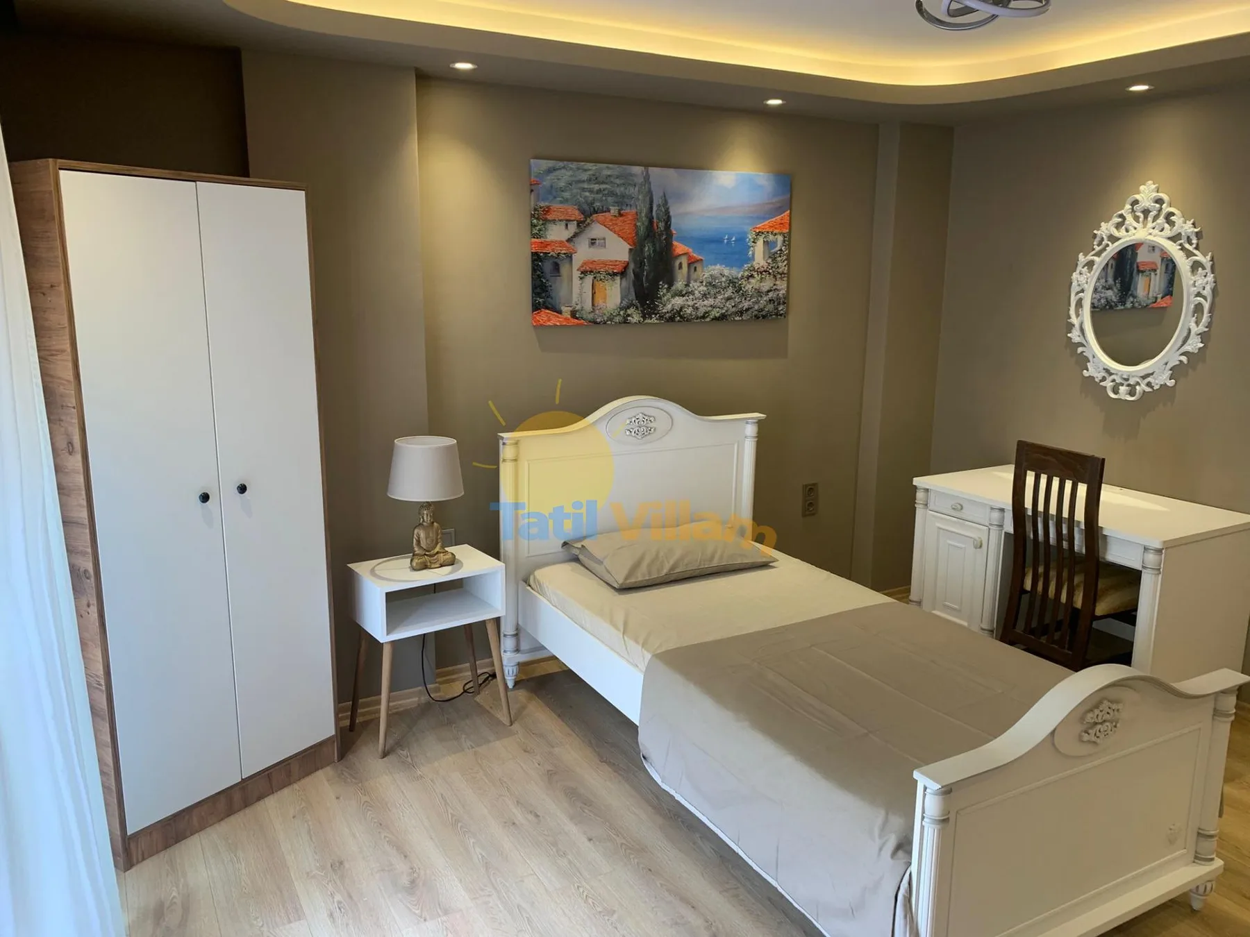 A bedroom with a single bed, a desk, and a wardrobe.