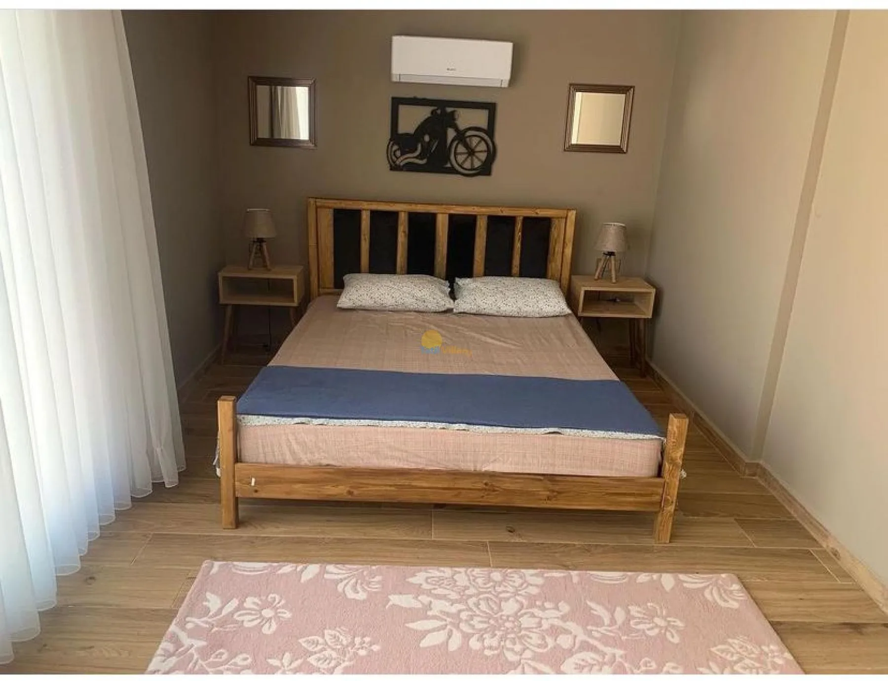 A bedroom with a wooden bed, bedside tables, and curtains.