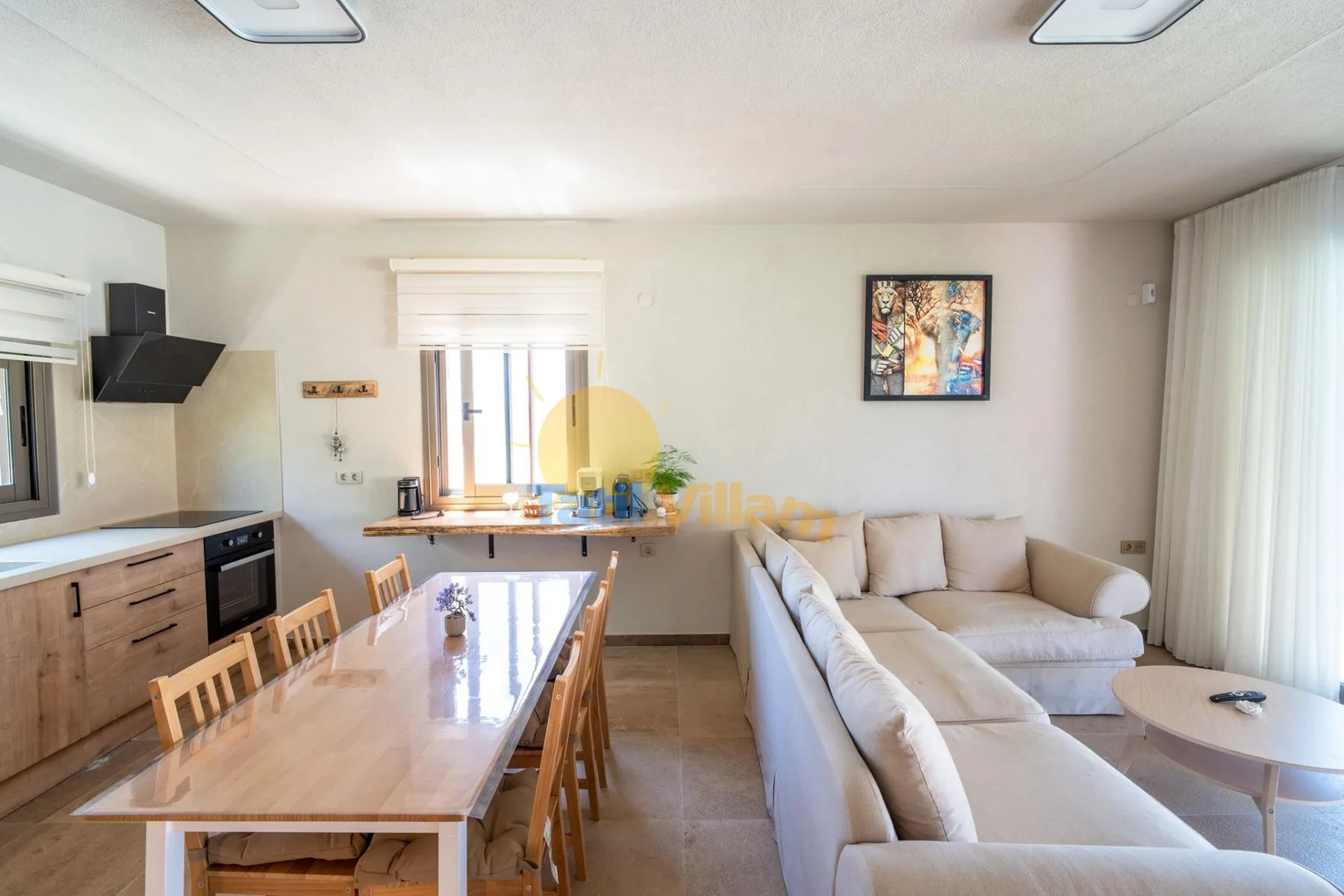 Una luminosa sala-comedor de planta abierta con la cocina junto a una pared.