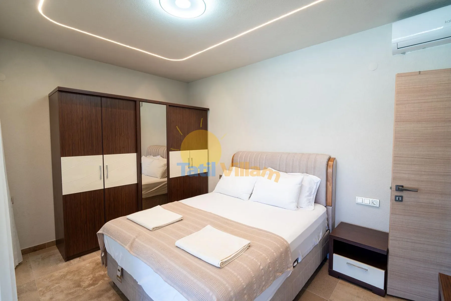 Un dormitorio con una cama doble, un armario y una mesita de noche.