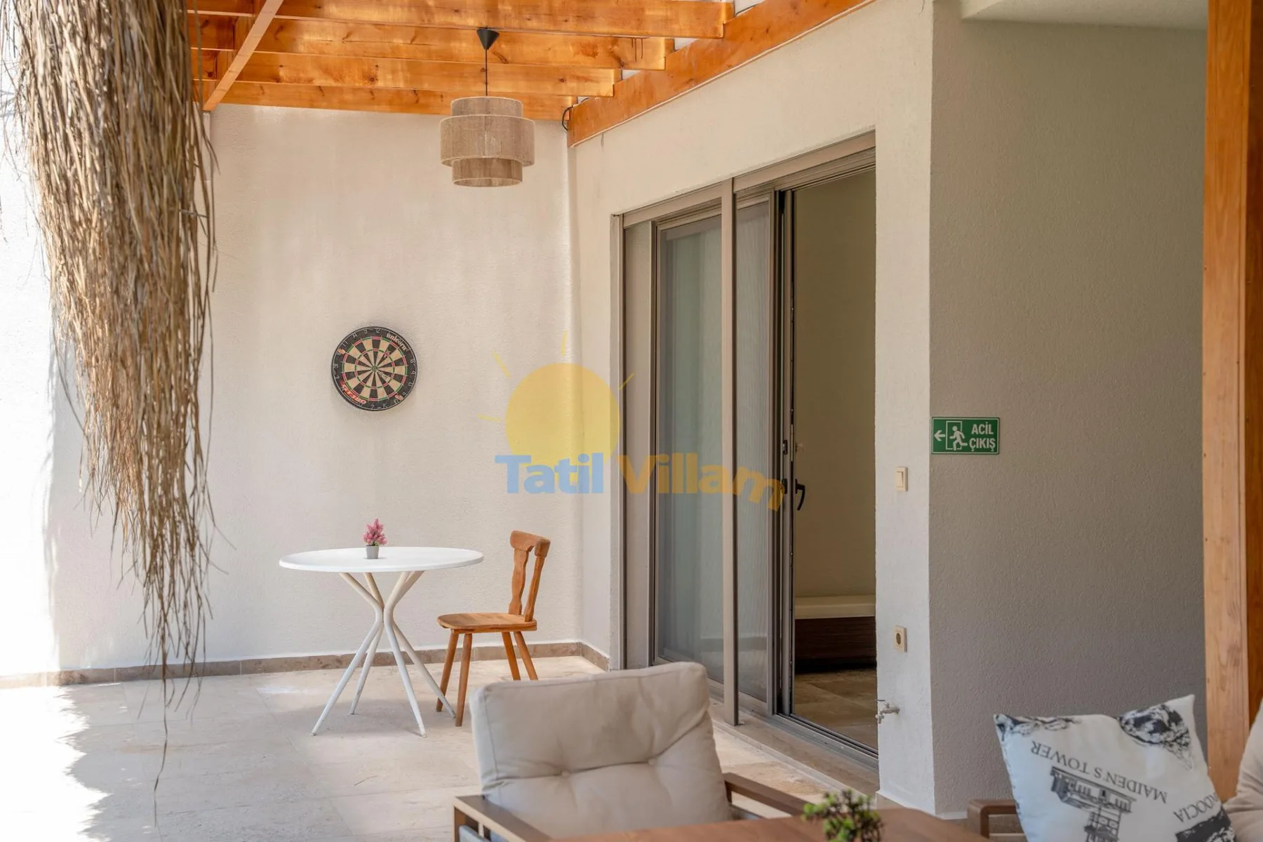 Una luminosa zona de estar con una mesa pequeña, sillas y puertas corredizas de vidrio.