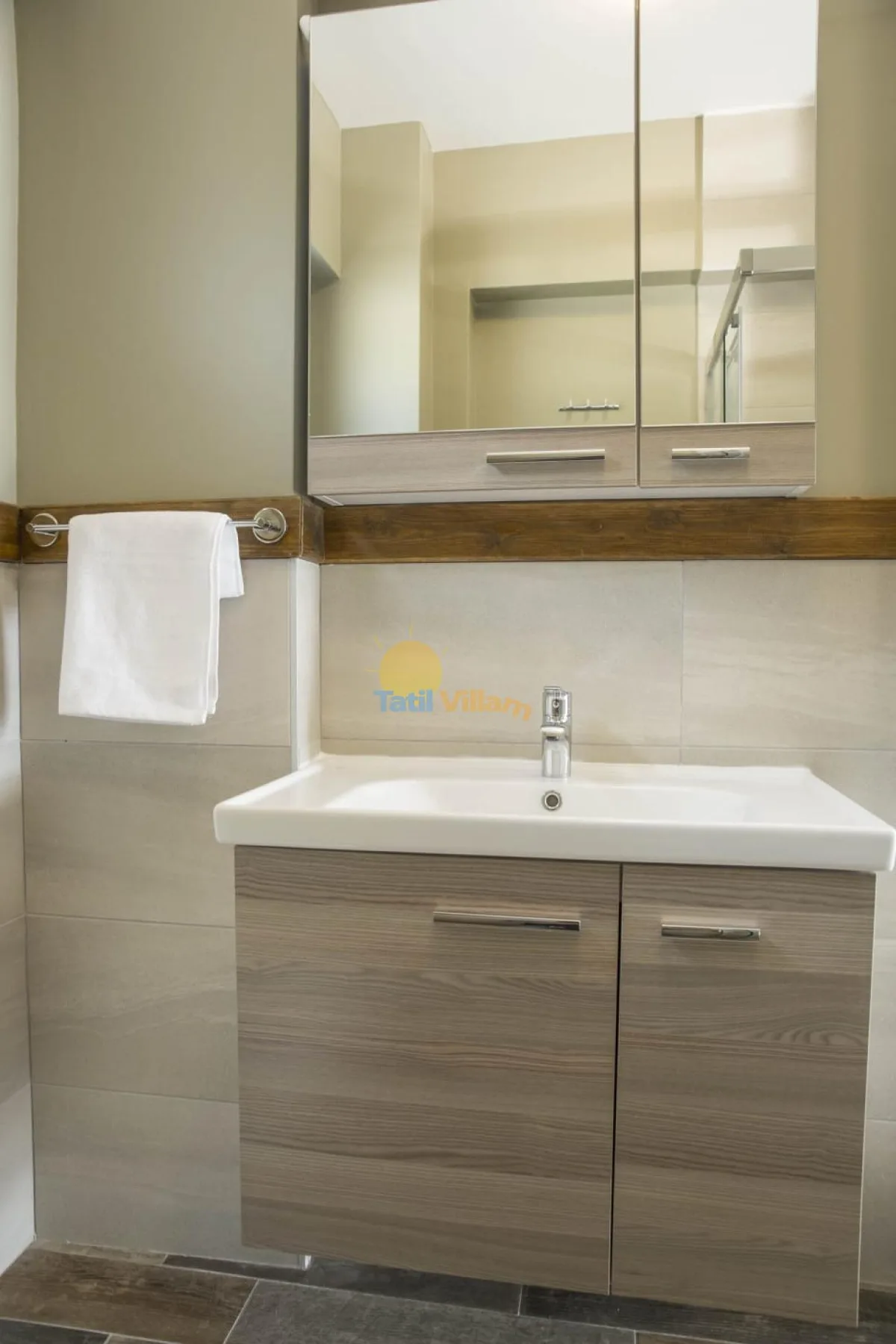 A bathroom vanity with a sink, mirrored cabinet, and towel rail.