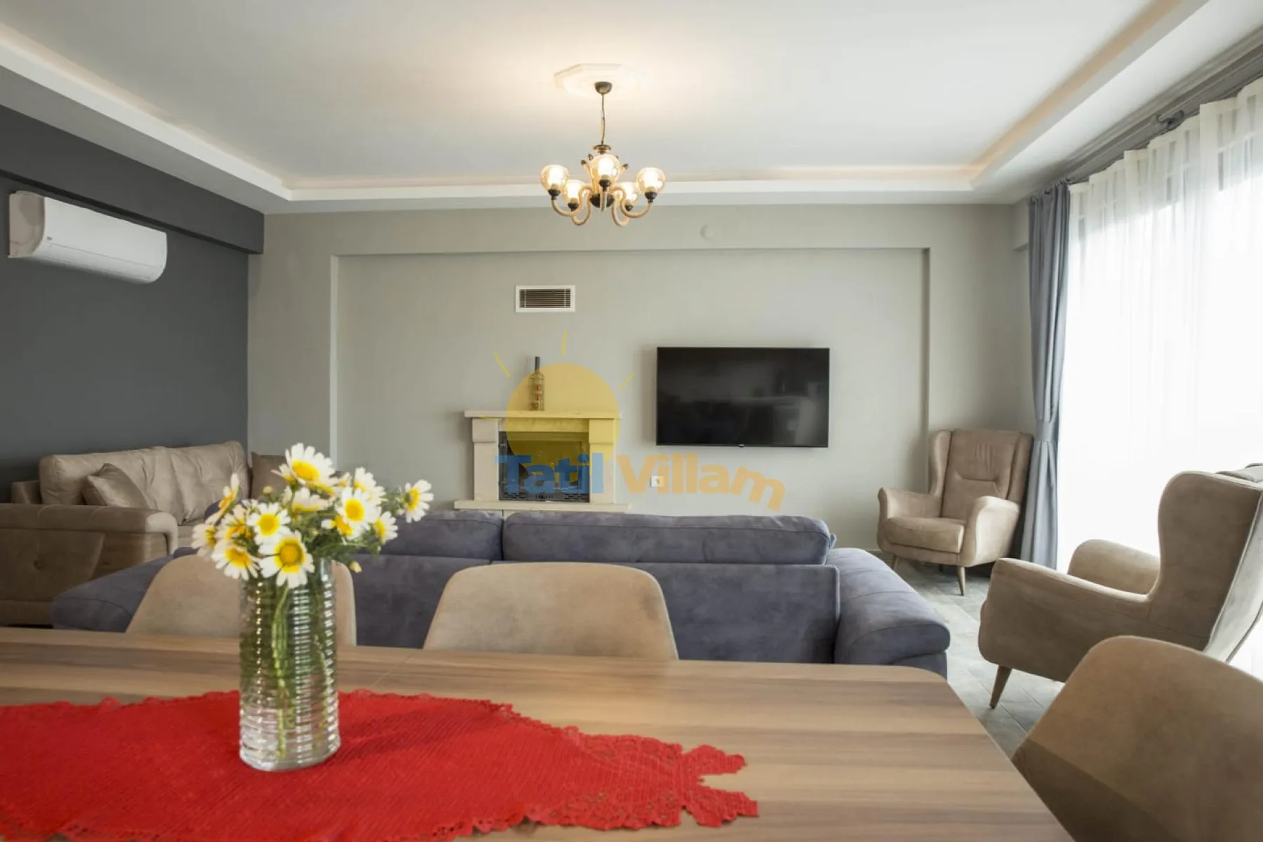 A living room with seating arranged around a television and a small fireplace.