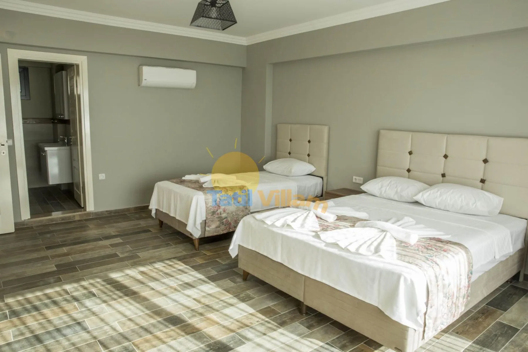 A bedroom with two beds, white linens, and gray walls.