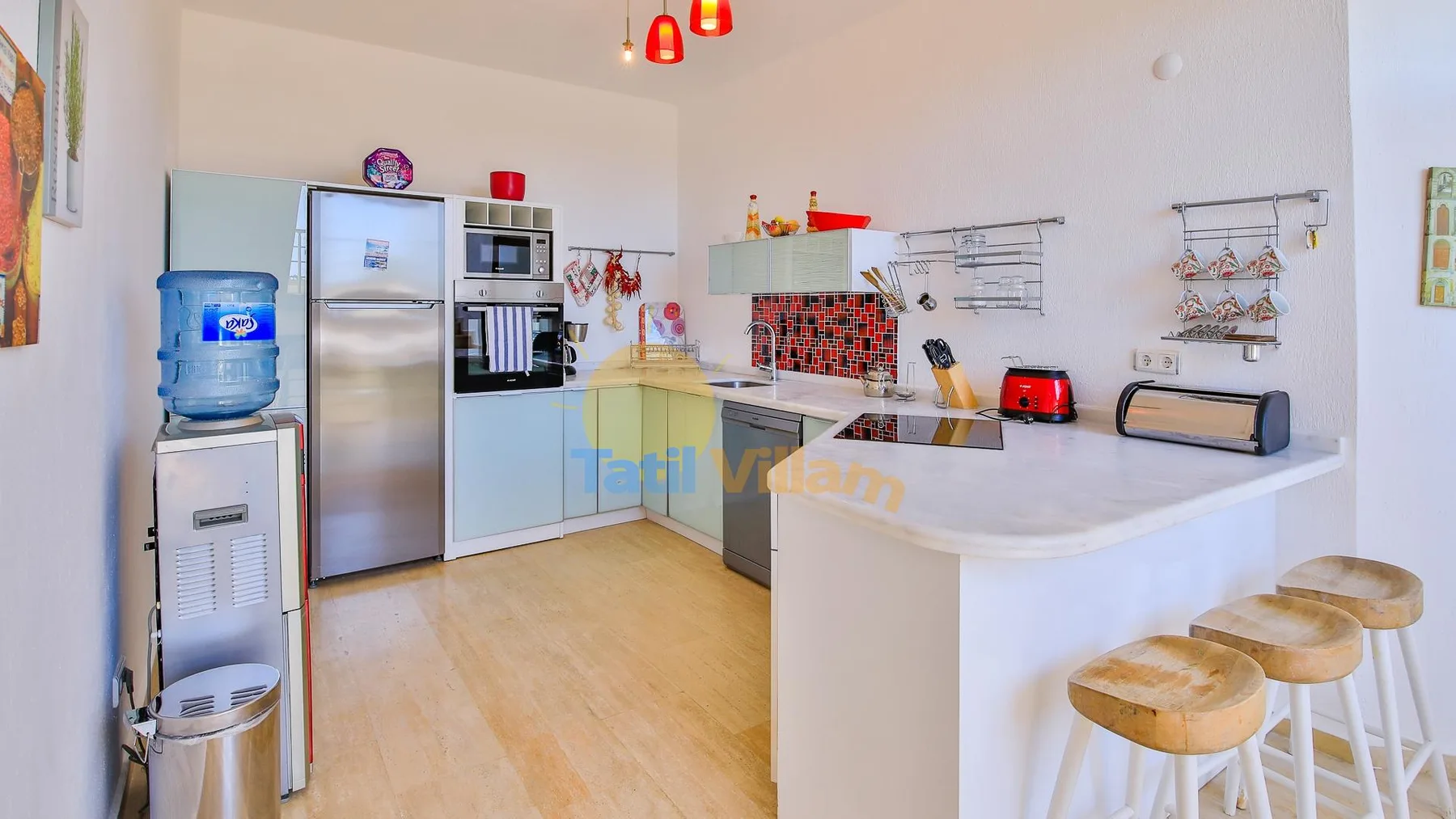 A bright kitchen with a central island and stainless-steel appliances.