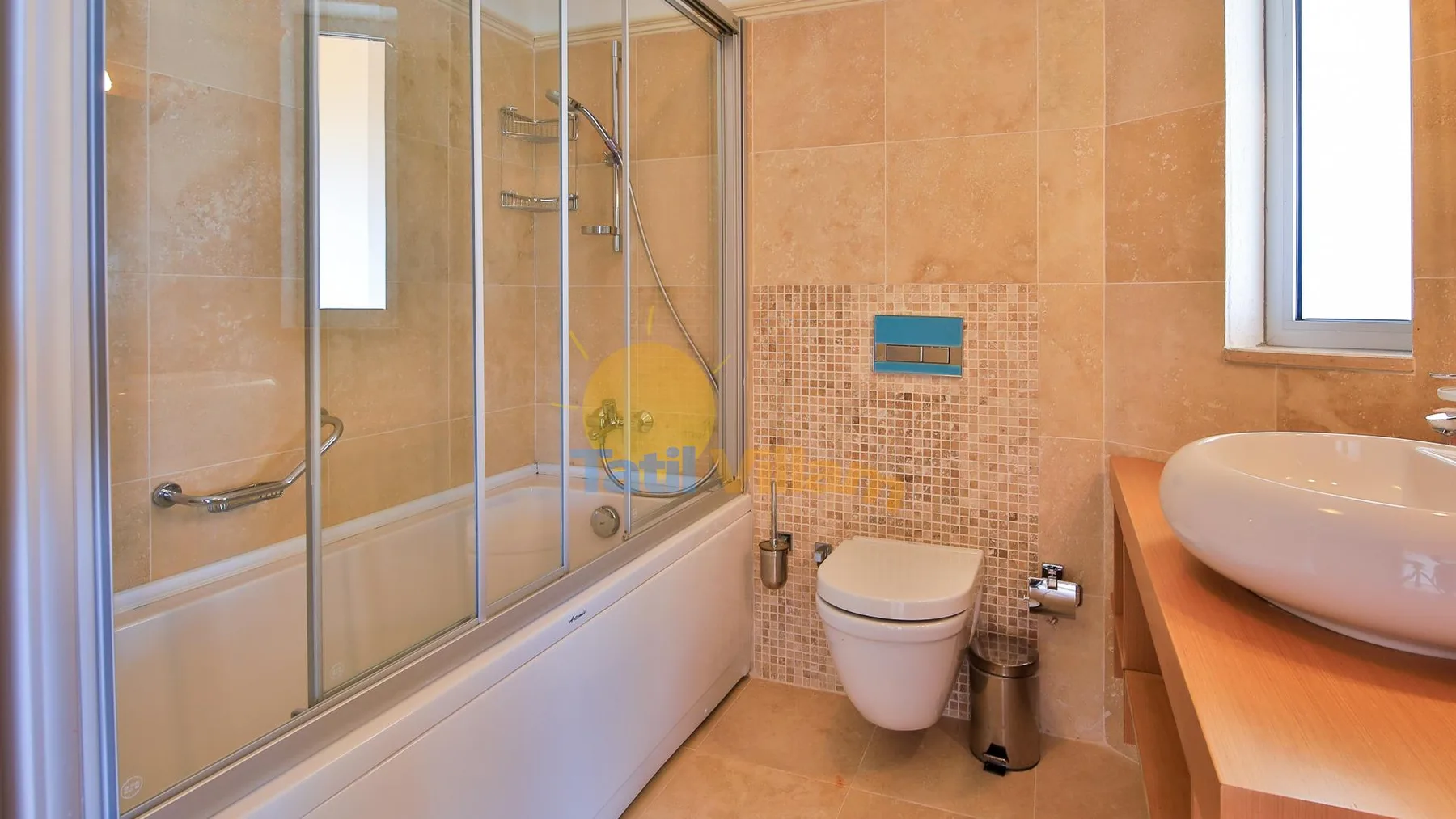 A tiled bathroom with a bathtub, shower, toilet, and sink.