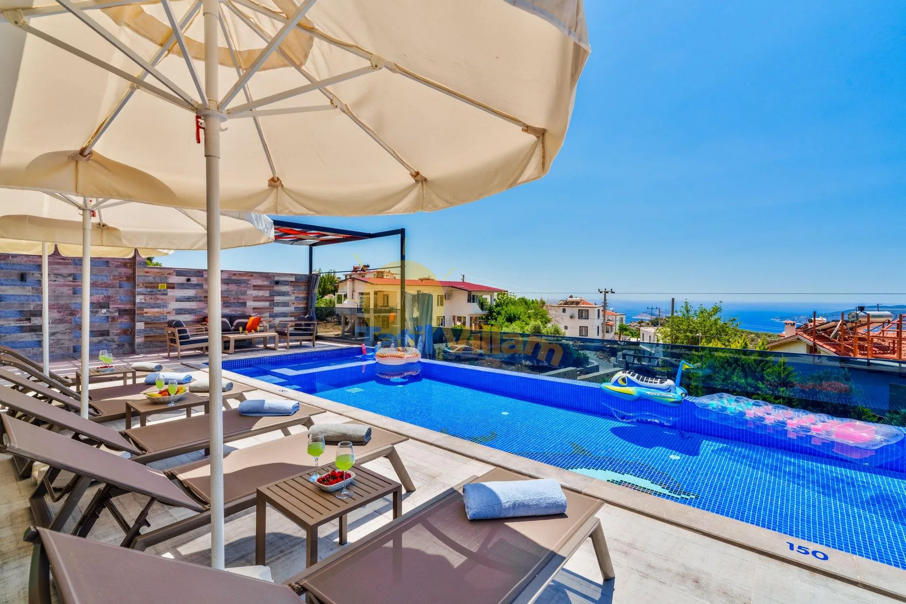 A rooftop pool with lounge seating and a view of the sea.