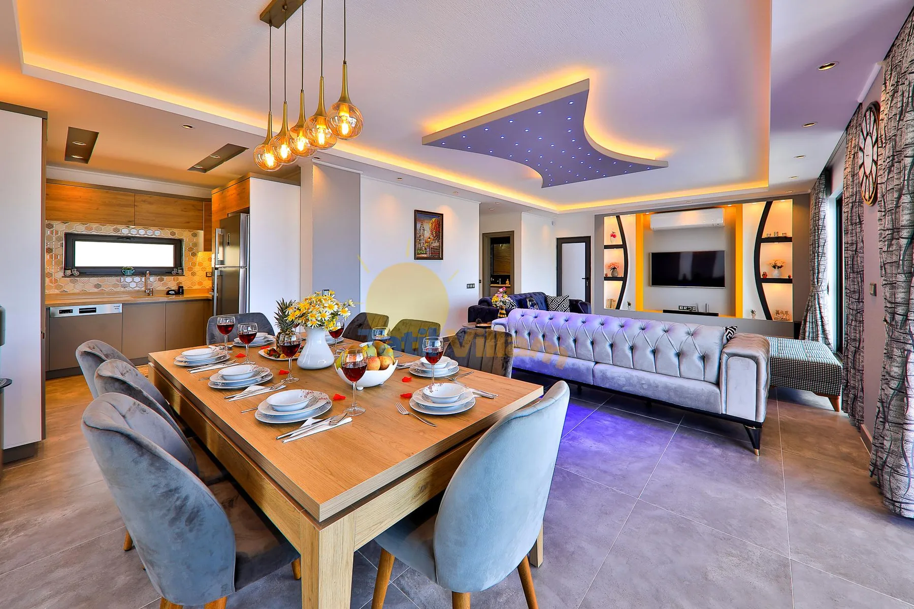 A modern open-plan living and dining room with a long dining table and seating.