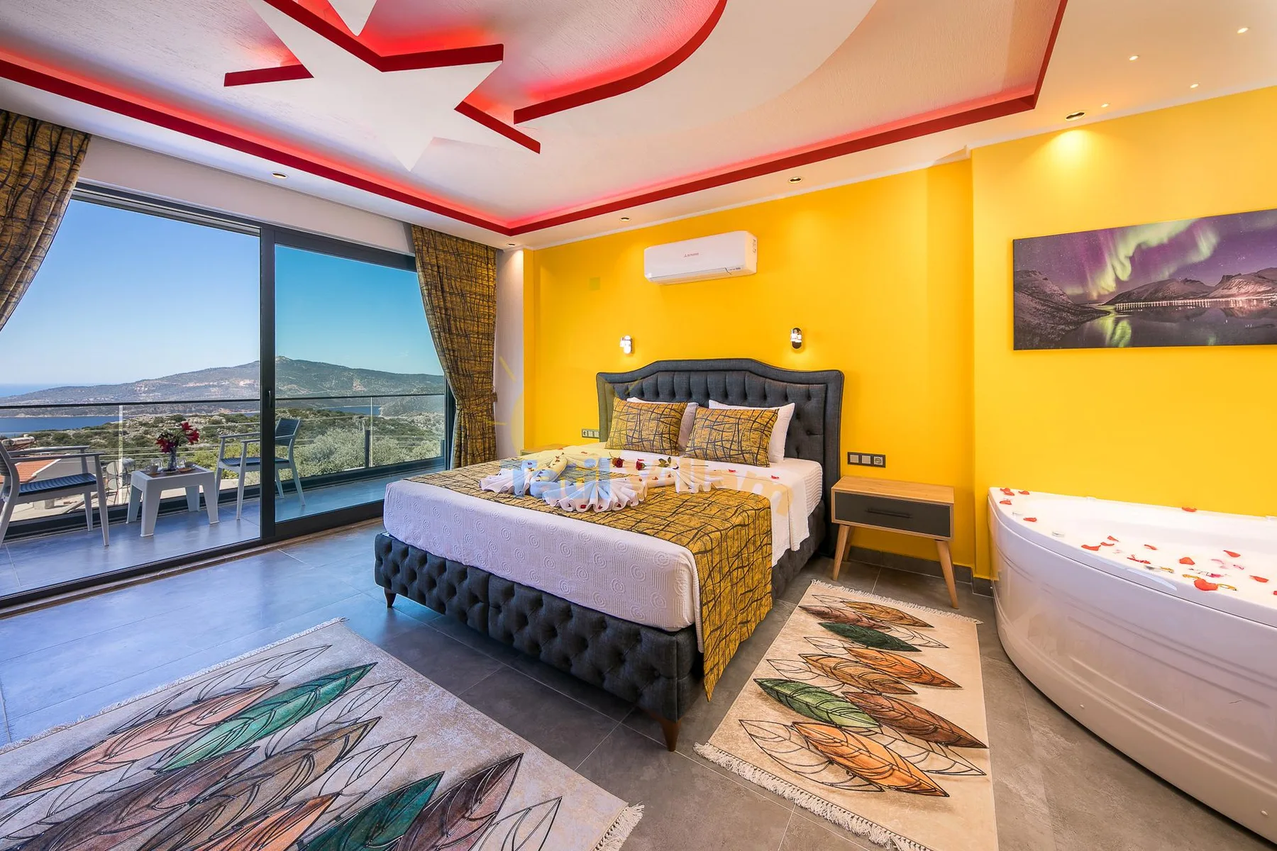 A bedroom with a bed beside a large window and a freestanding bathtub.