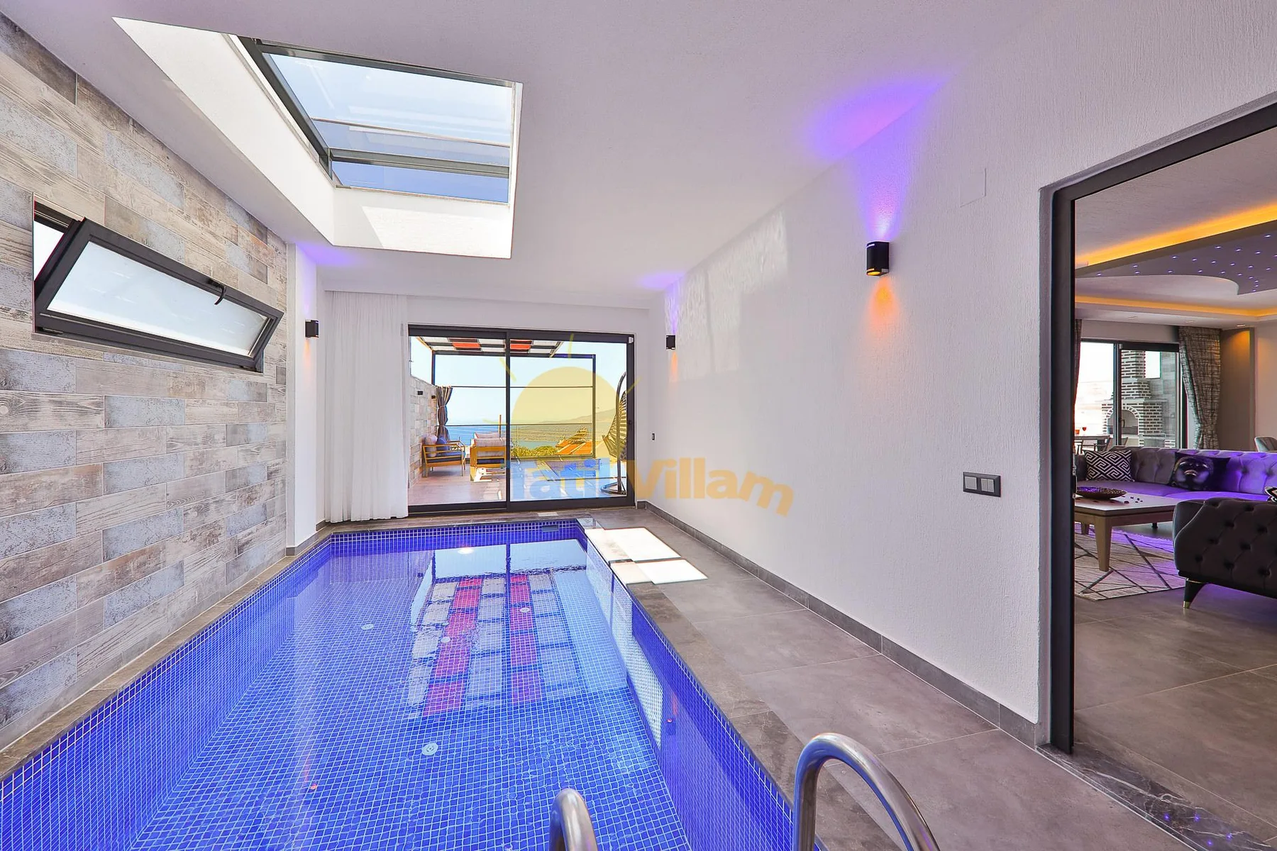 An indoor swimming pool sits beside a large window and a tiled wall.