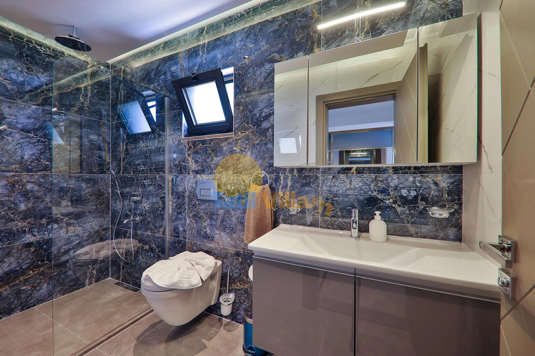 A modern bathroom with a sink, mirror, and glass shower.